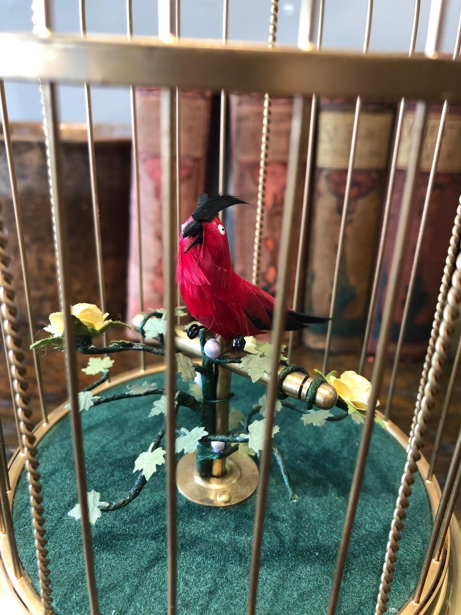 This late 19th century musical bird automaton is entertaining wonder of mechanics with its automated singing bird with a strong voice and flamboyant plumage amidst foliage in a gilded brass cage. Comes with a lifetime warranty in ever in need of
