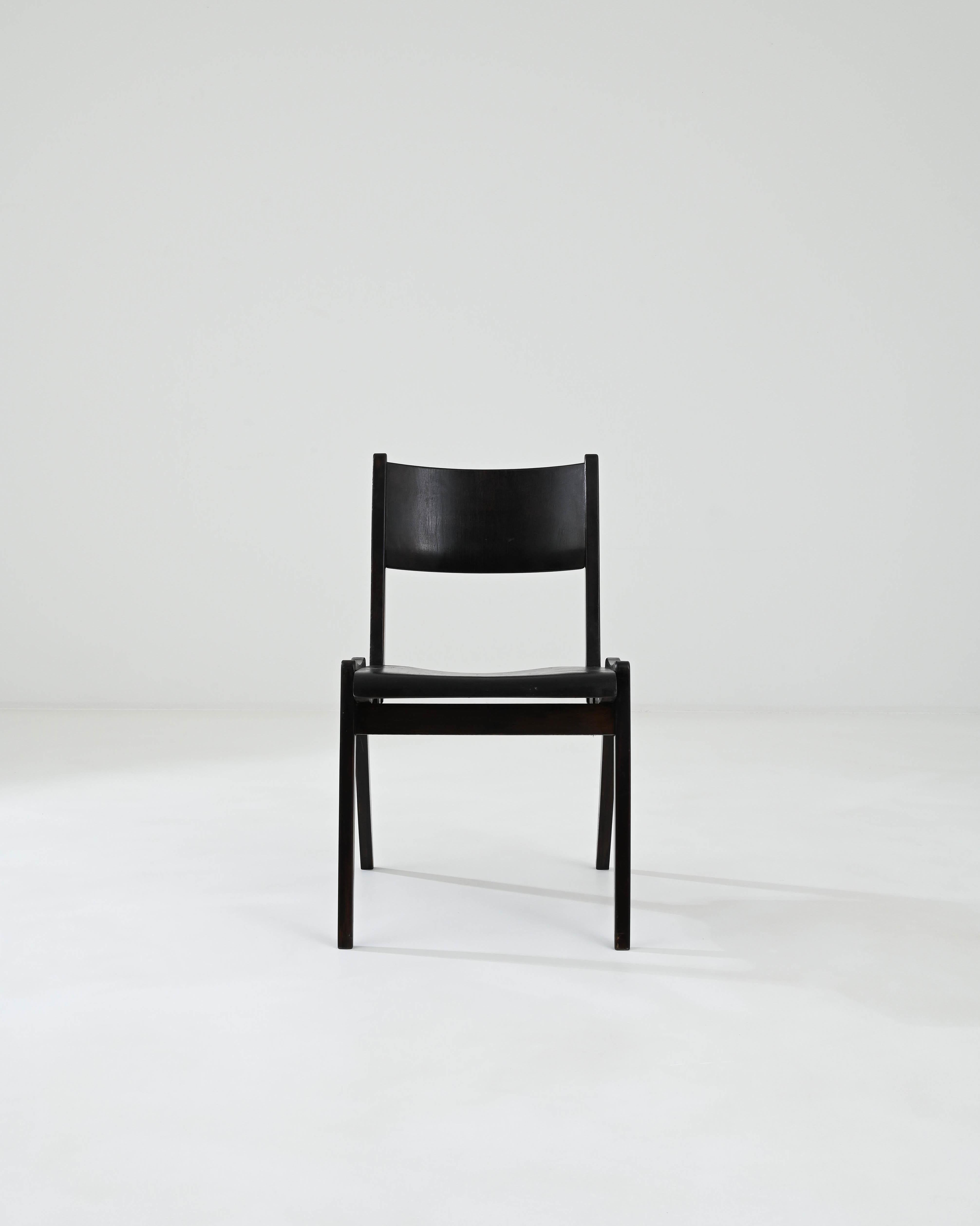 Introducing our exquisite 20th Century German Wooden Dining Chair, a timeless piece that effortlessly blends classic design with modern functionality. This chair, crafted from high-quality dark wood, showcases the impeccable craftsmanship typical of