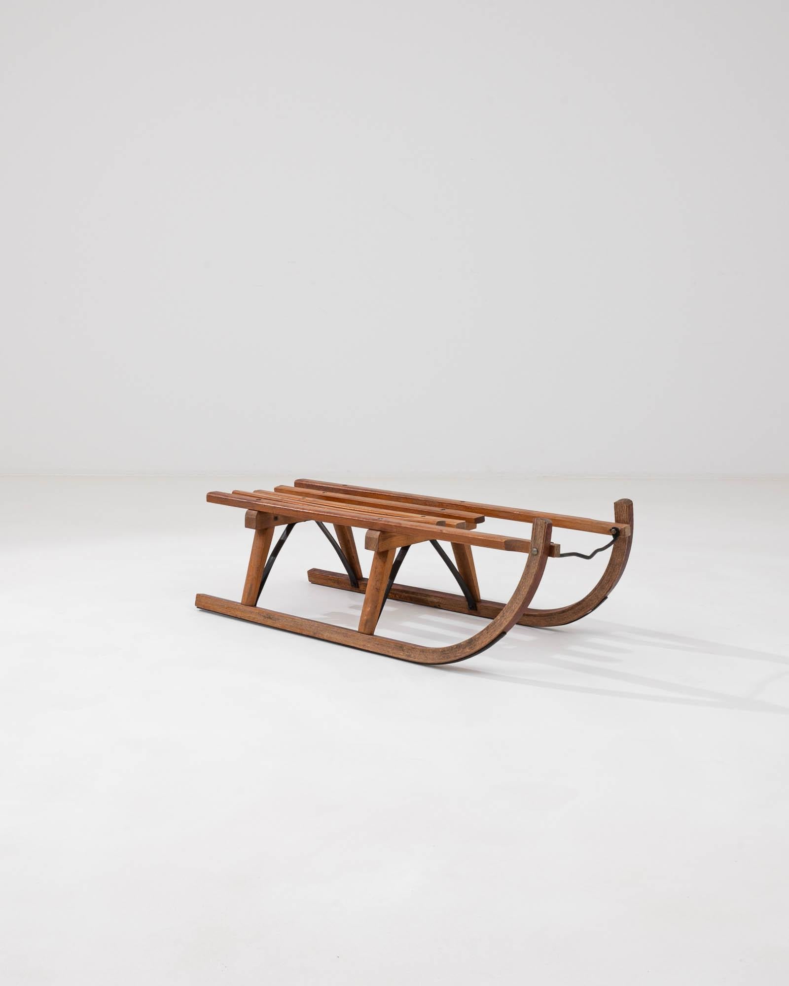 Introducing a remarkable piece of winter's past: the 20th Century German Wooden Sled by Davos. A nostalgic tribute to the snowy days of yore, this sled is a genuine collector's item, evoking the simple joy of gliding over a fresh blanket of snow.