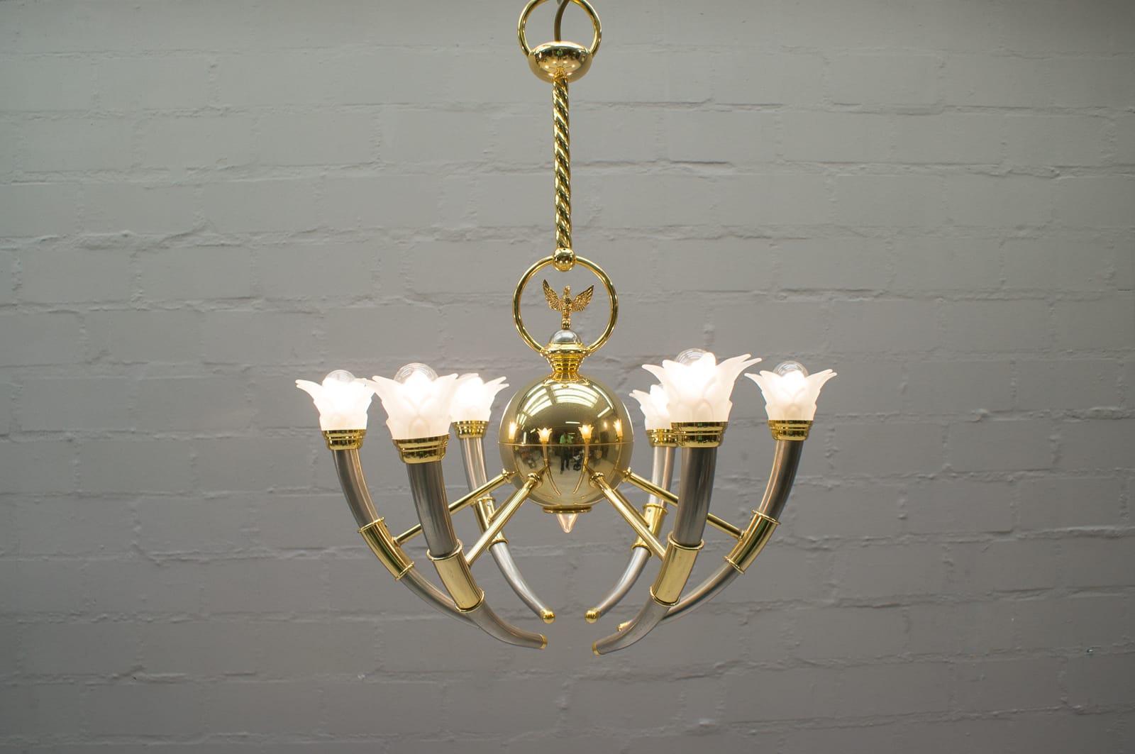 Rare and beautiful 20th century gilted brass and glass flowers chandelier from the 1970s.

At the center of the chandelier you will find a brass ball that have a light at the extremity. At the top of the chandelier there is a beautiful brass