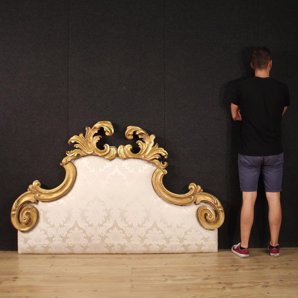 Elegant bed headboard from the 70s/80s. Furniture composed of a panel covered in very pleasant damask fabric with carved and antique gilded wooden decoration. Headboard with great charm and strong visual impact. Ancient baroque wooden elements