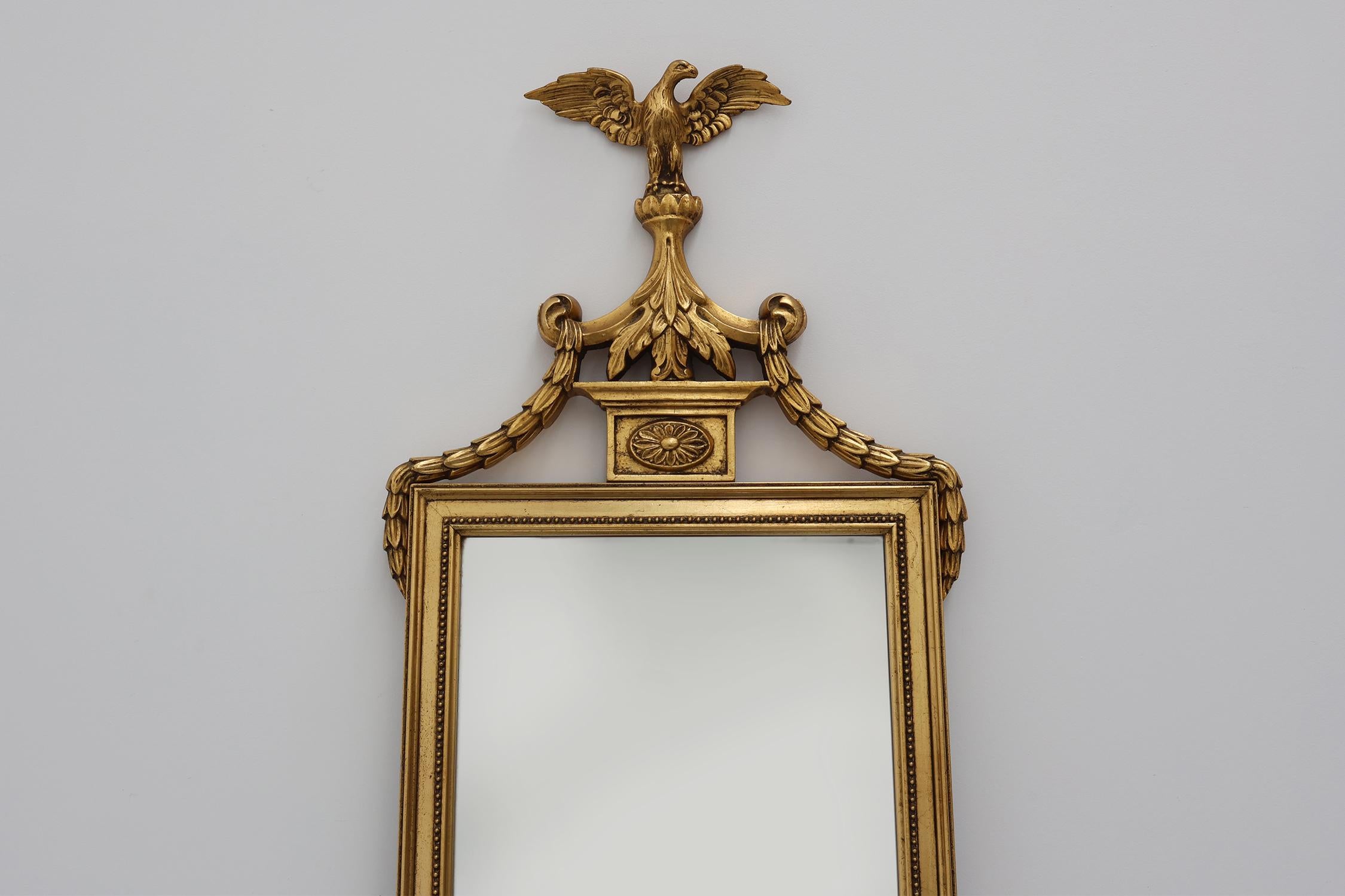 Neoimpero 20th Century gilded wooden Empire style mirror with eagle on top in vendita