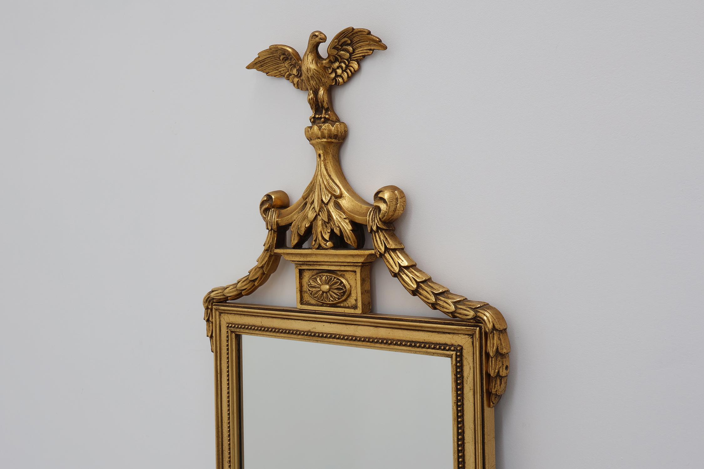 Specchio 20th Century gilded wooden Empire style mirror with eagle on top in vendita
