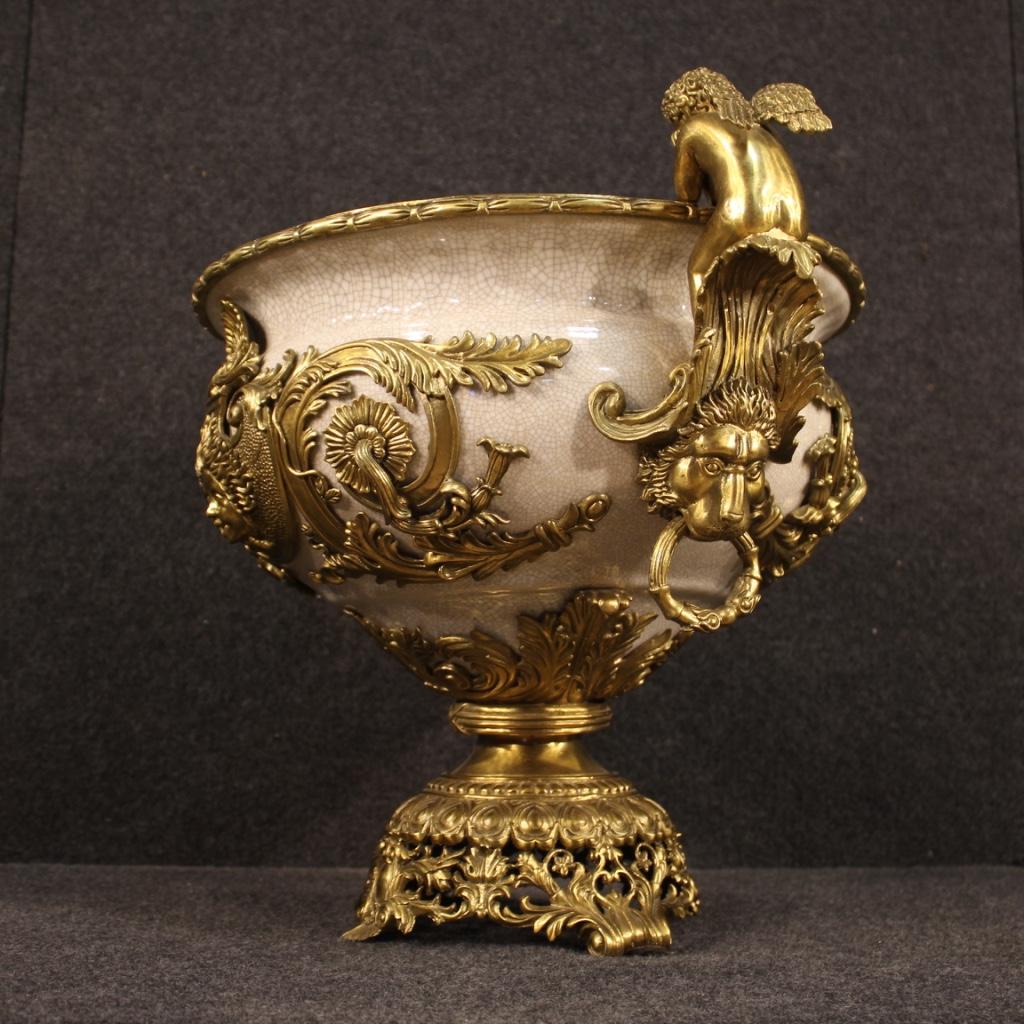 French cup from the second half of the 20th century. Object of great measure and fabulous decor in gilded metal and glazed ceramic. Vase complete with handles and lateral decorative cherubs of great pleasure. Reproduction of an important antique