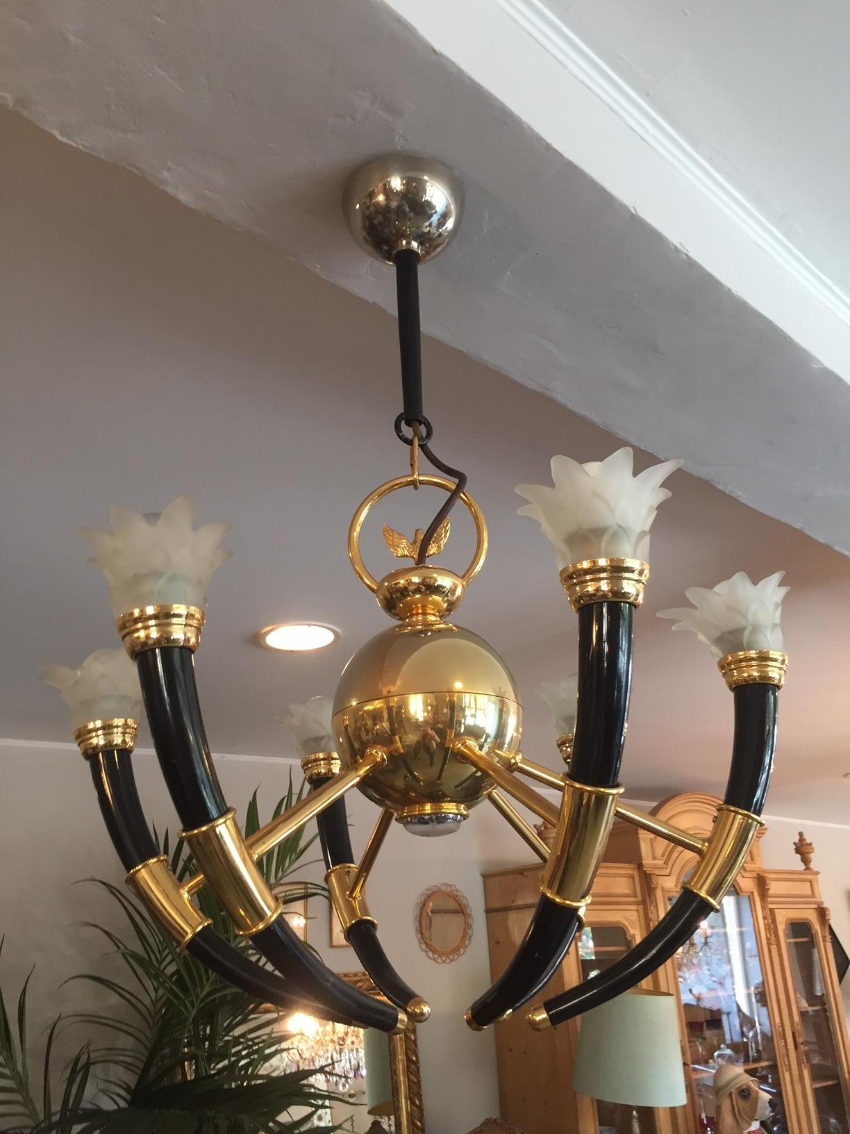 Rare and beautiful 20th century gilted brass and glass flowers chandelier from the 1970s.
At the center of the chandelier you will find a brass ball that have a light at the extremity. At the top of the chandelier there is a beautiful brass eagle.