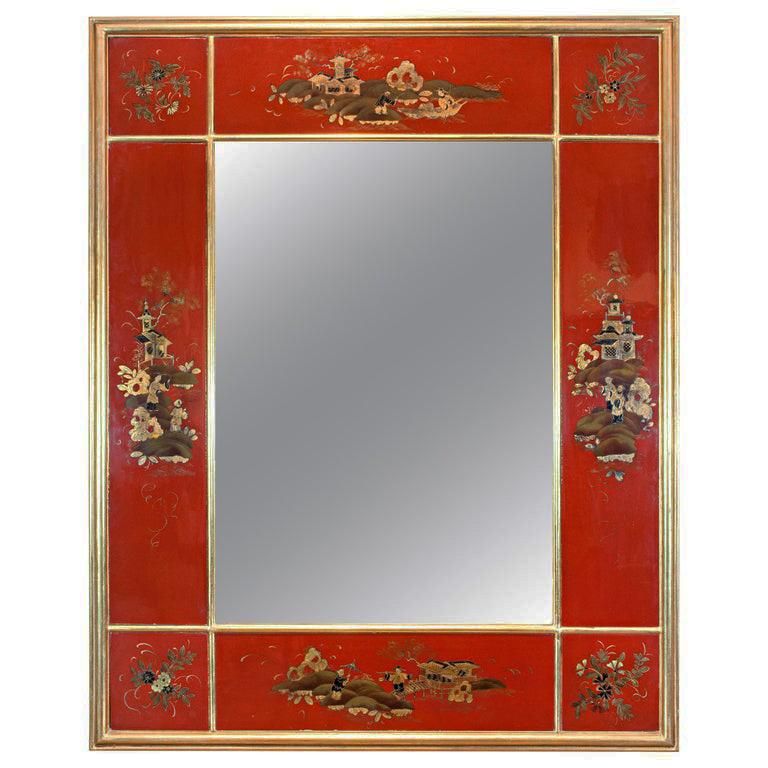 A rare red Japanned mirror depicting floral and Japanese architecture surrounded by a giltwood frame.