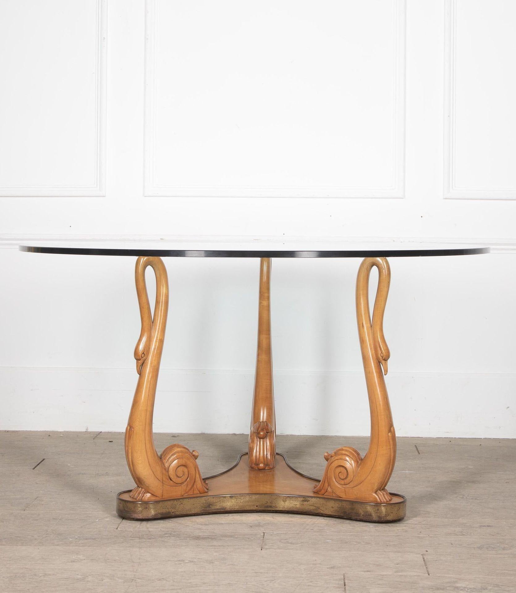 20e siècle Table centrale circulaire italienne avec trois cols et têtes de cygnes supportant un plateau en verre circulaire biseauté.
La base est ornée d'une décoration en laiton.
Cette magnifique table aurait été conçue par l'Italien Osvaldo