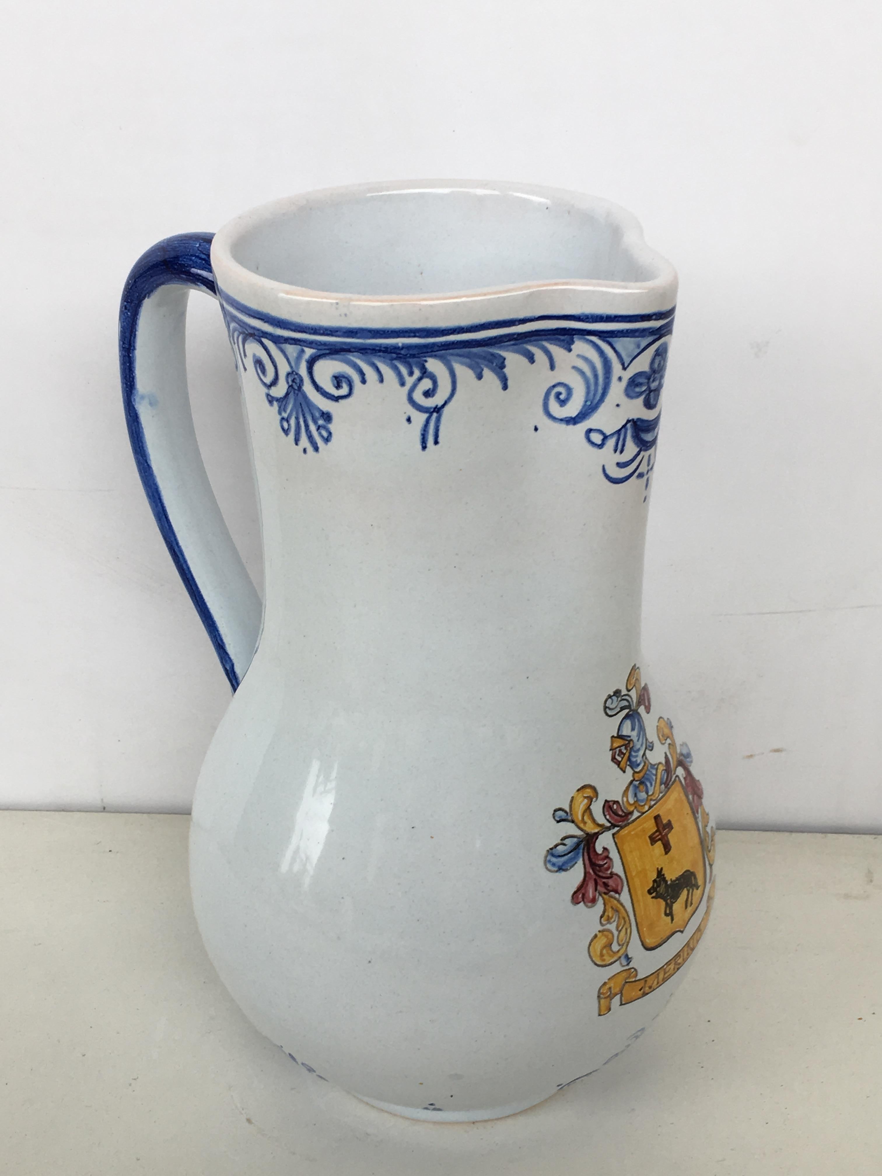 A striking Spanish glazed earthenware handled blue and white painted pitcher, the body underglaze blue decorated & heraldic shield

Talavera de la Reina pottery is a craft made in Talavera de la Reina, Toledo (Spain). Dishes, jars and other