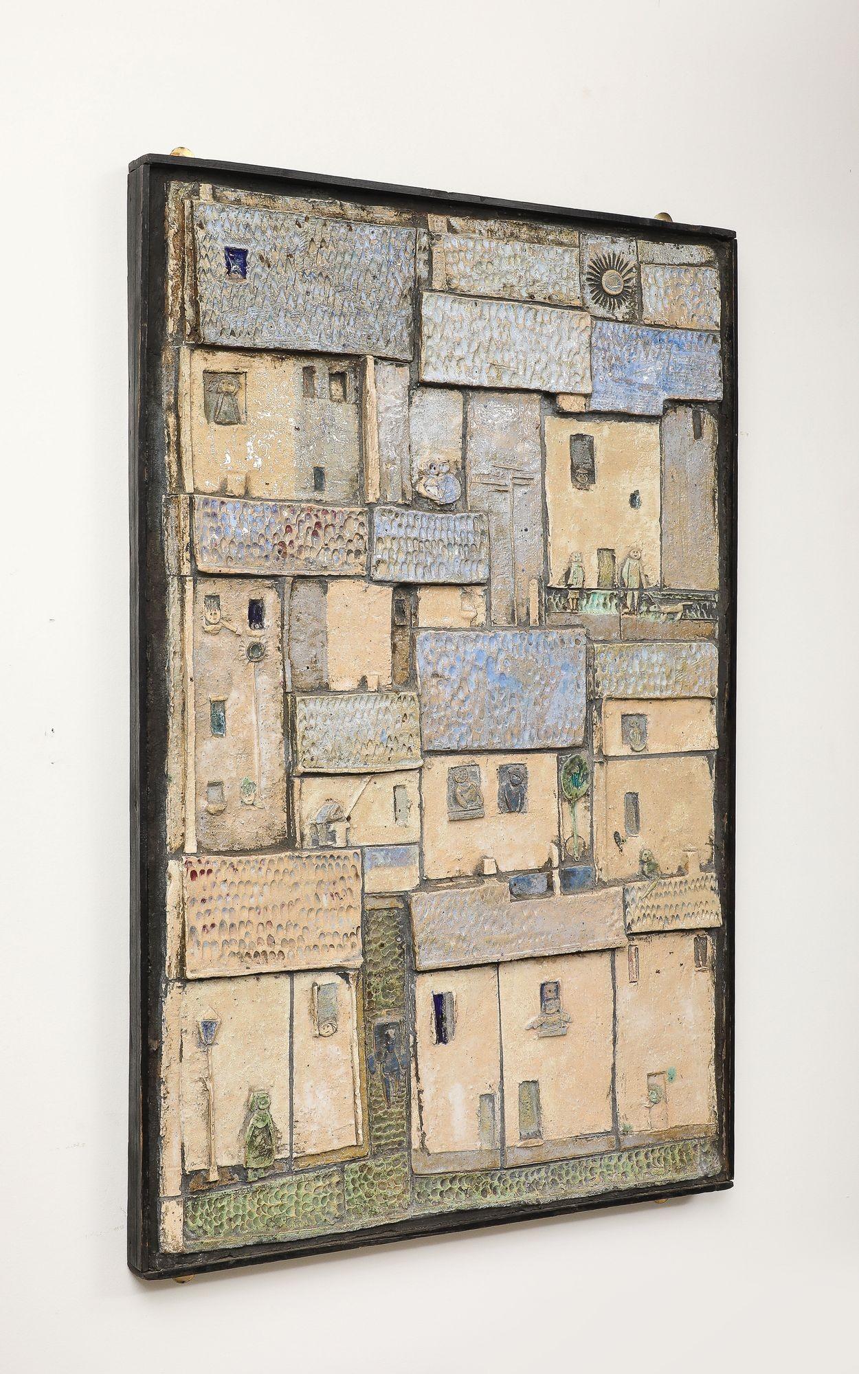 Diese glasierte Studiotafel aus der Mitte des 20. Jahrhunderts zeigt eine stilisierte Dorfszene aus bearbeitetem Ton mit Figuren, Tieren und einem strahlenden Sonnenaufgang. Das um 1960 in Frankreich gefertigte Stück spiegelt die Vorliebe der