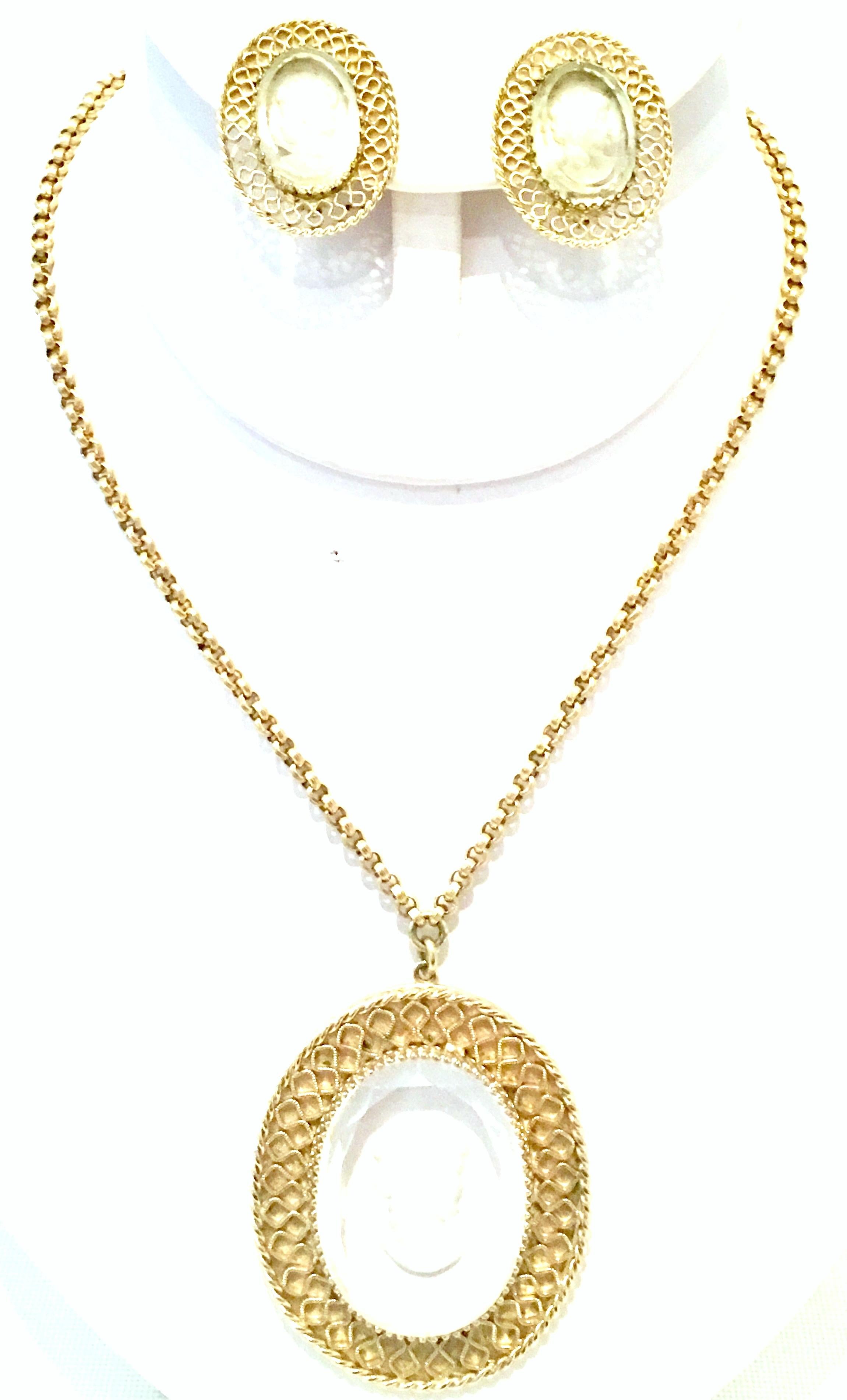 20th Century Gold Plate And Reverse Carved Art Glass Pendant Necklace And Earrings By, Whiting & Davis. This finely crafted three piece set features gold plate metal with fancy prong set translucent reverse carved glass cameo. The Clip style pair of