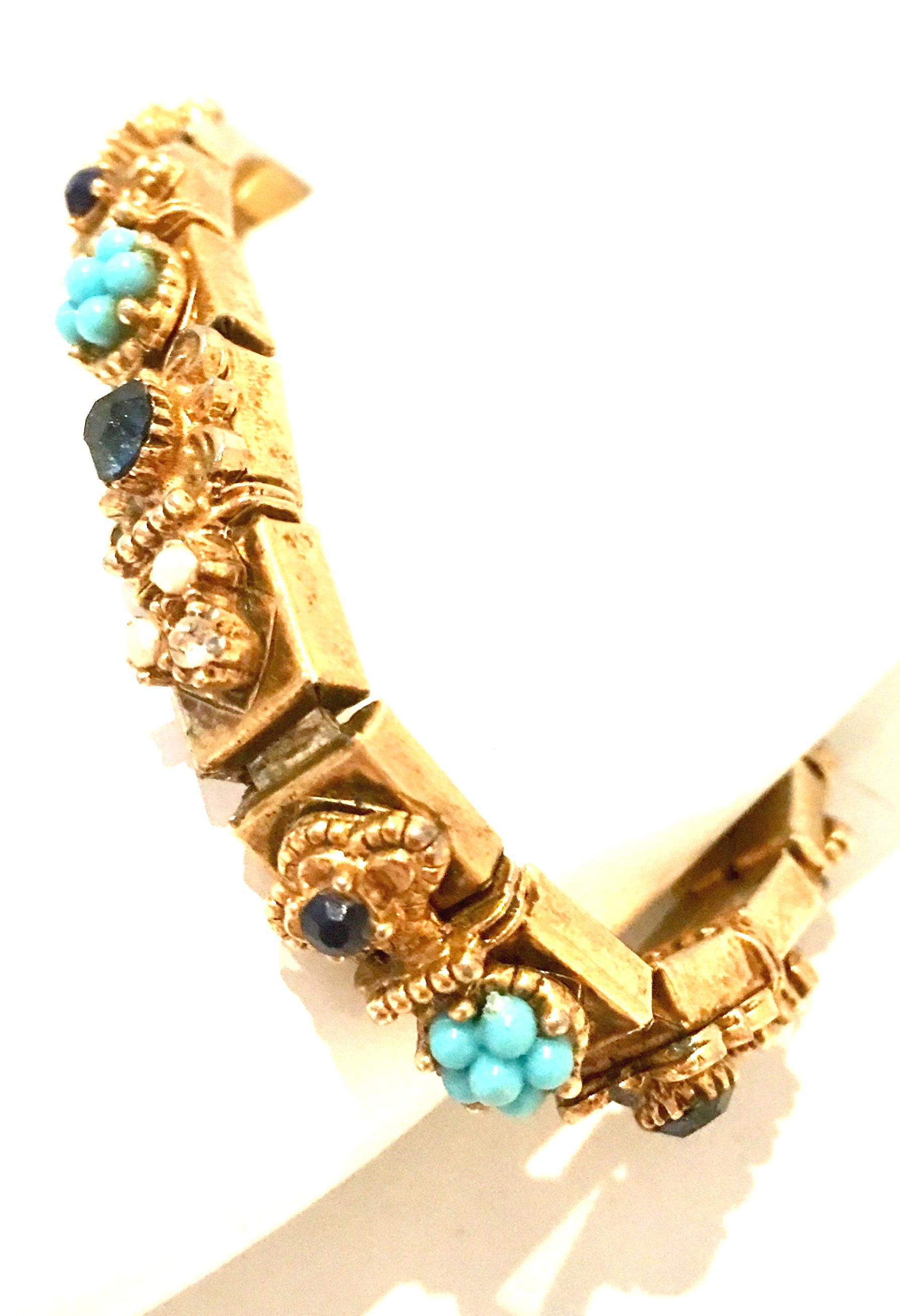 Mid-20th Century Etruscan Style Gold Plate, Austrian Crystal & Bead Link Bracelet.
This unique gold plate seventeen square link bracelet features applied charms of faux pearl and turquoise beads as well as Austrian crystal blue sapphire stones. The
