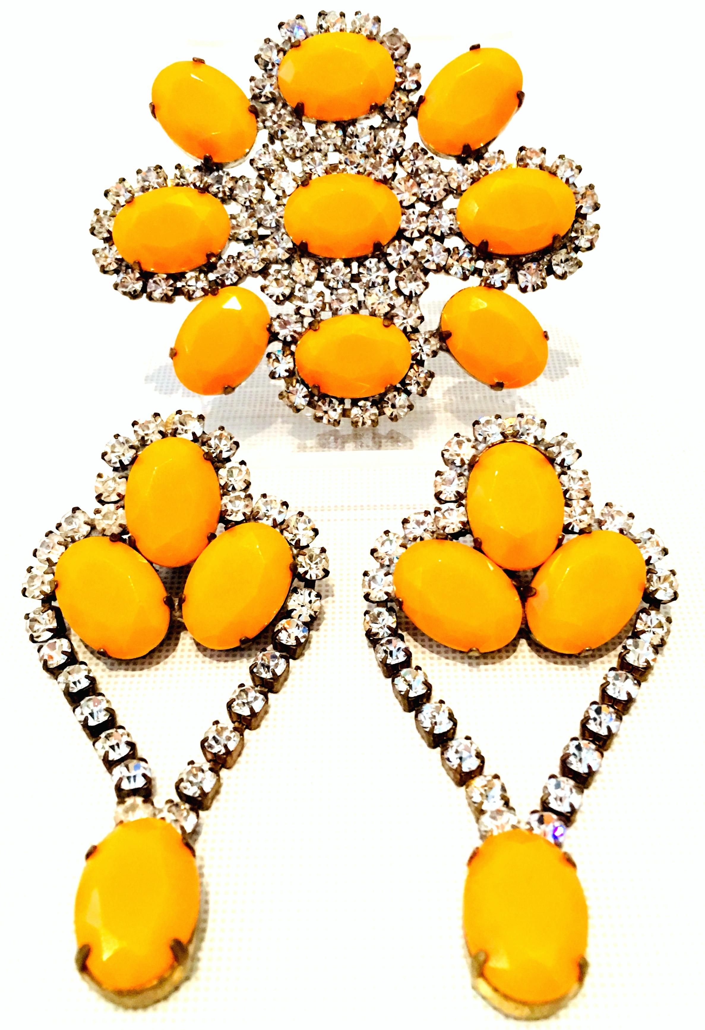 20th Century Gold & Austrian Crystal Bohemian Brooch & Pair Of Chandelier Earrings.
This Bohemia style three piece set features a gold tone base metal with fancy prong set brilliant colorless stones and large cut and faceted resin stones. The large