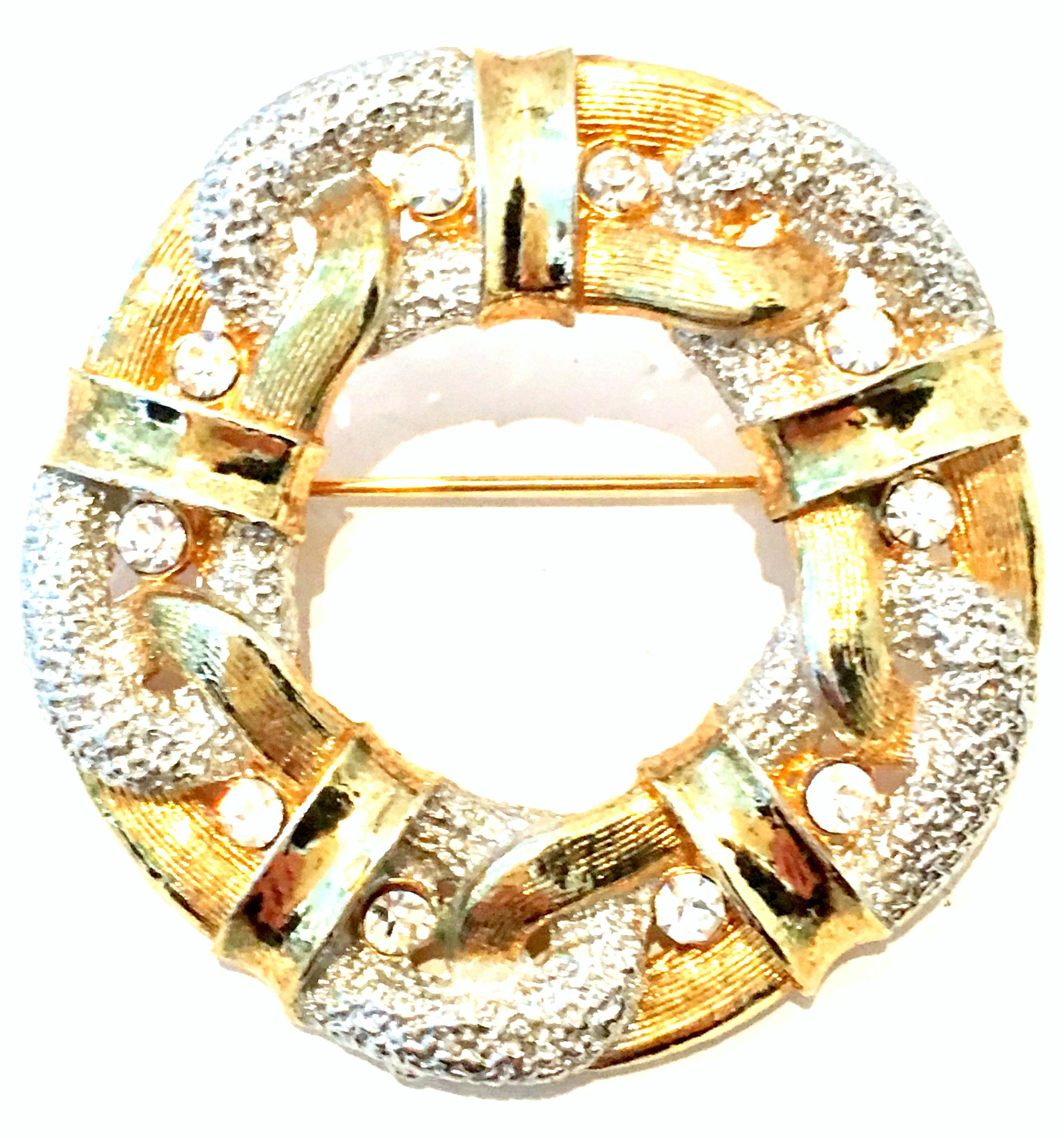 20th Century Gold Plate & Austrian Crystal Dimensional Brooch. This finely crafted dimensional brooch features gold plate metal, raised ribbon like detail with pave set brilliant colorless Austrian crystal stones.