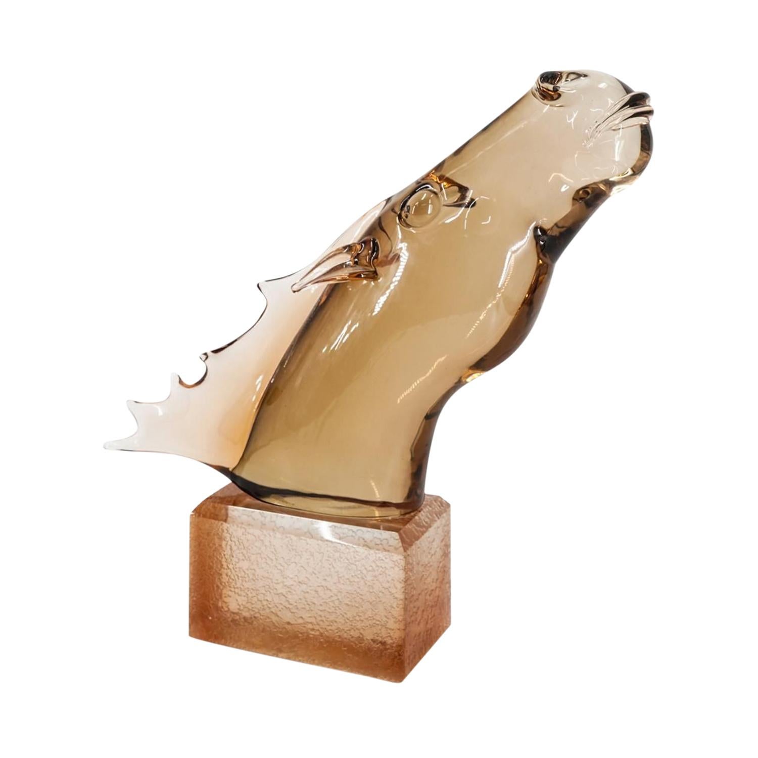 A gold-brown, vintage Mid-Century Modern Italian horse sculpture made of hand blown colored Murano glass, designed and produced by Pino Signoretto in good condition. The slightly smoked, arched décor piece is resting, sitting on a rectangular block