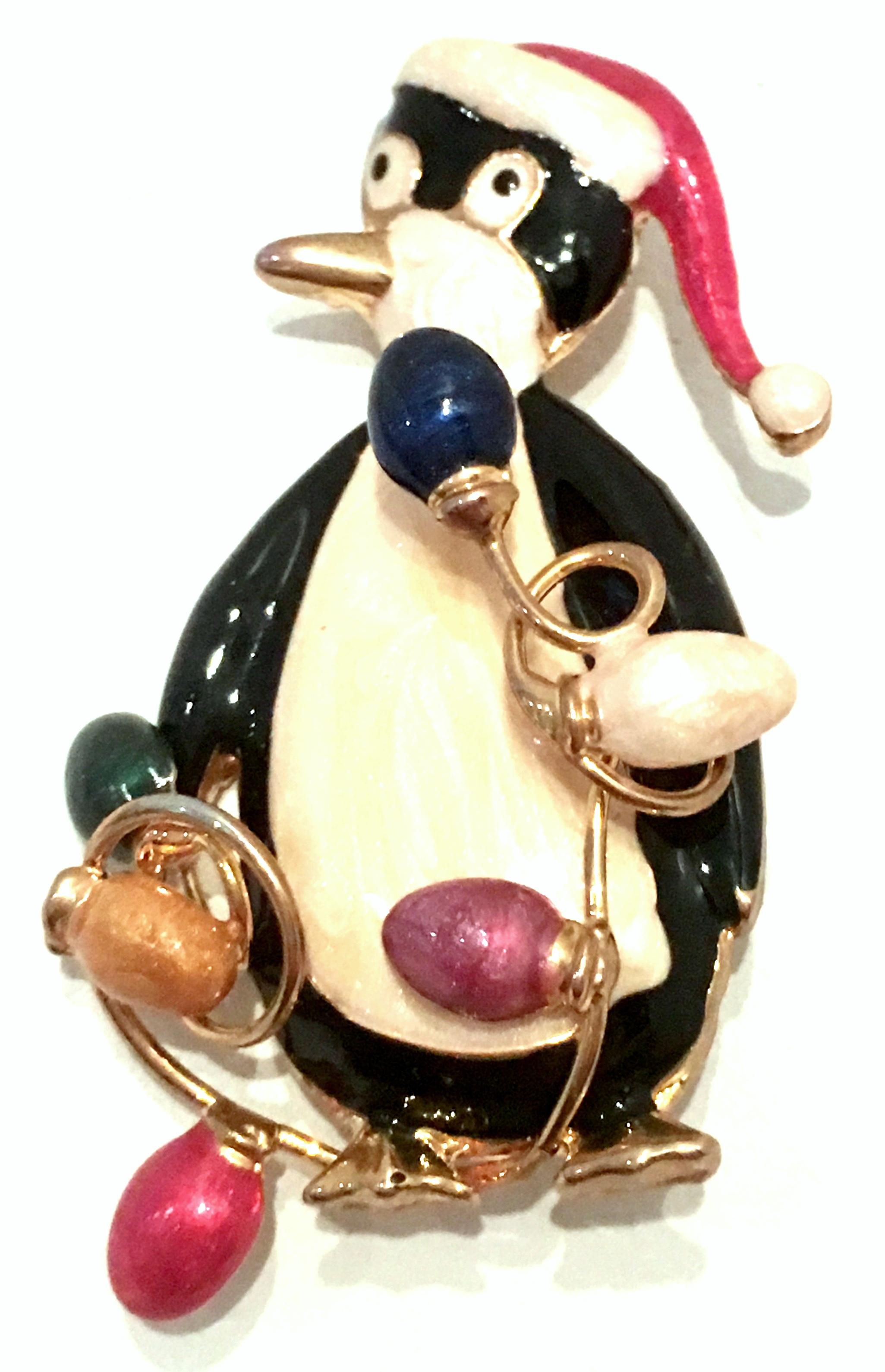 20th Century Gold & Enamel Christmas Penguin Brooch By, TC. This finely crafted festive gold plate, hand painted enamel Penguin brooch features a penguin with a Santa Claus hat, holding abstract tangled Christmas lights. Marked on the underside, TC