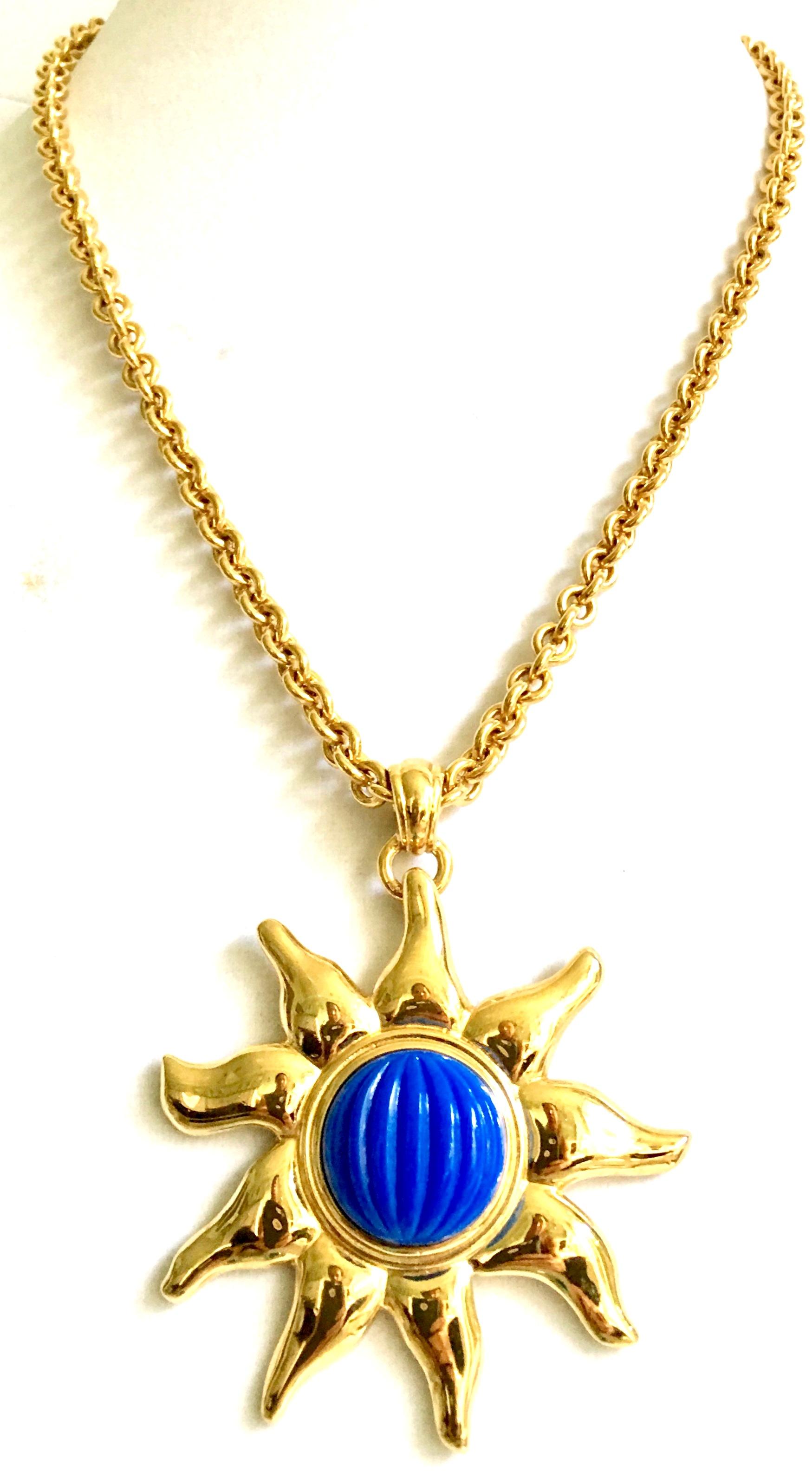 1980'S Gold Plate & Faux Blue Lapis Starburst Pendant Chain Link Necklace By, Monet. Features a gold plate chain link long locking claw style clasp necklace and large faux blue central stone gold starburst pendant.
Pendant is approximately, 3