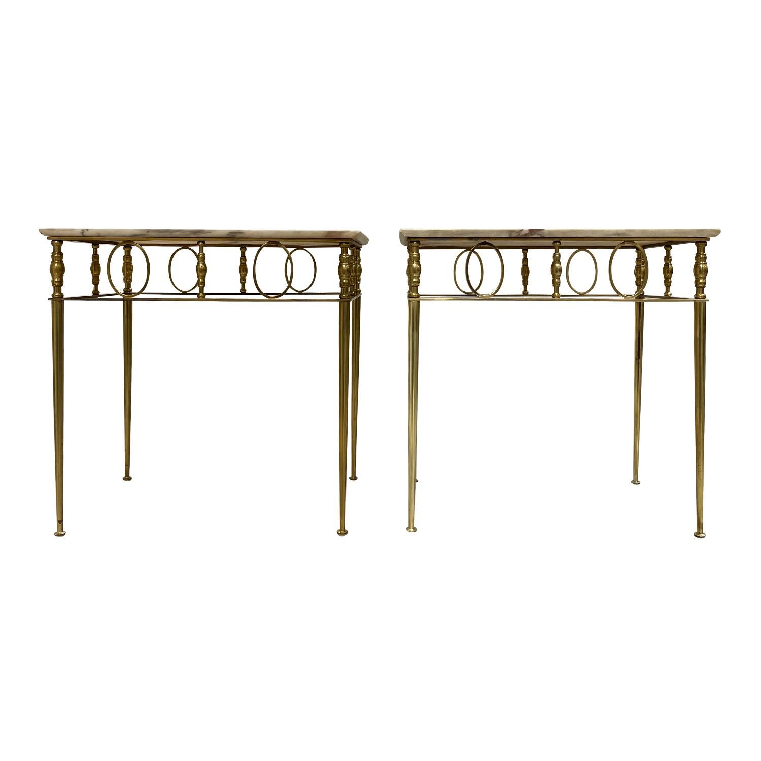 A gold, vintage Art Deco French pair of side tables made of hand crafted polished brass with a cream-white marble top, in good condition. The small Parisian sofa tables are standing on four thin round legs, enhanced by detailed décor. Minor