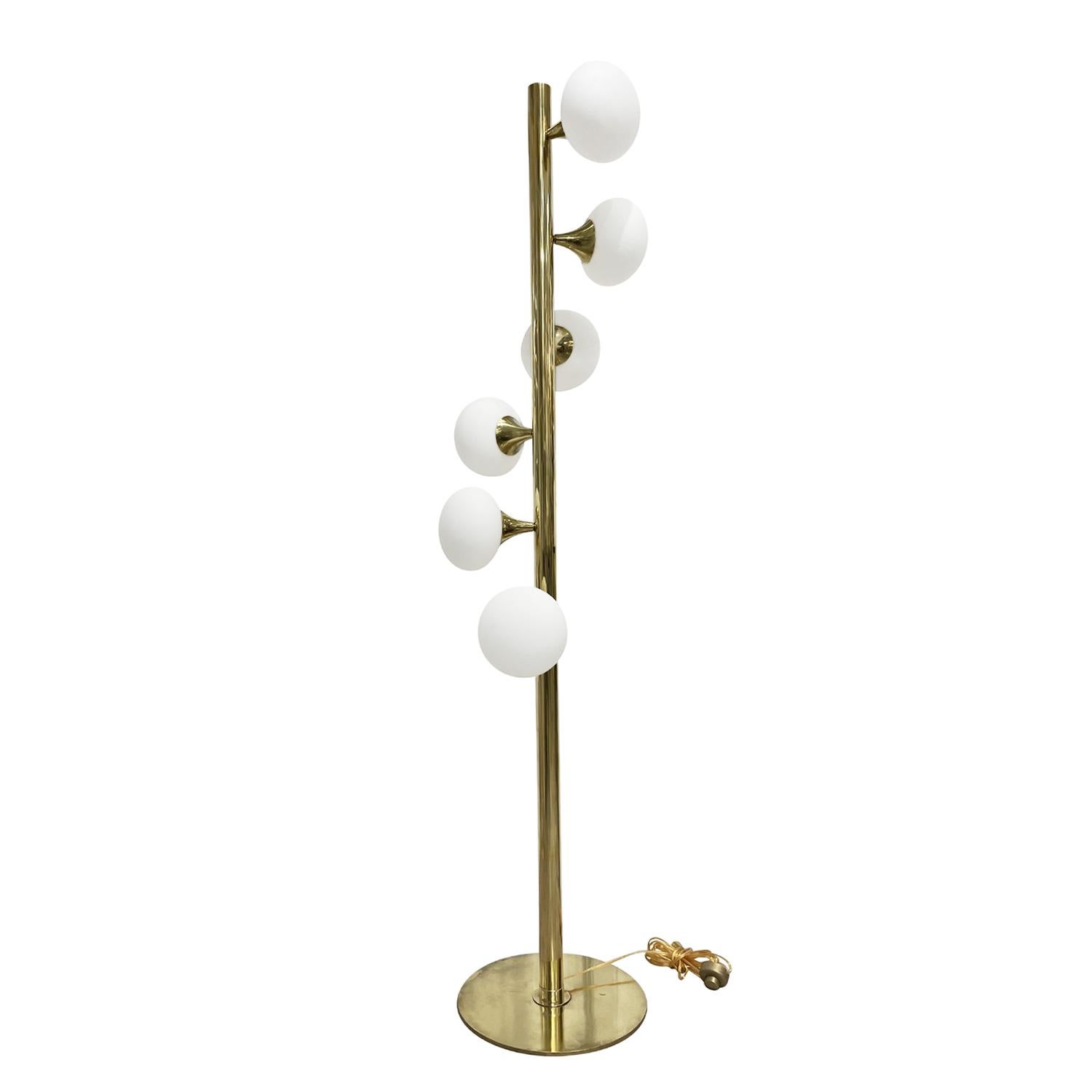 A gold, vintage Mid-Century Modern Italian floor lamp made of hand crafted polished brass, designed and produced by Stilnovo, in good condition. The floor lamp is composed with six frosted opaline glass shades, each of the glass lights are halted by