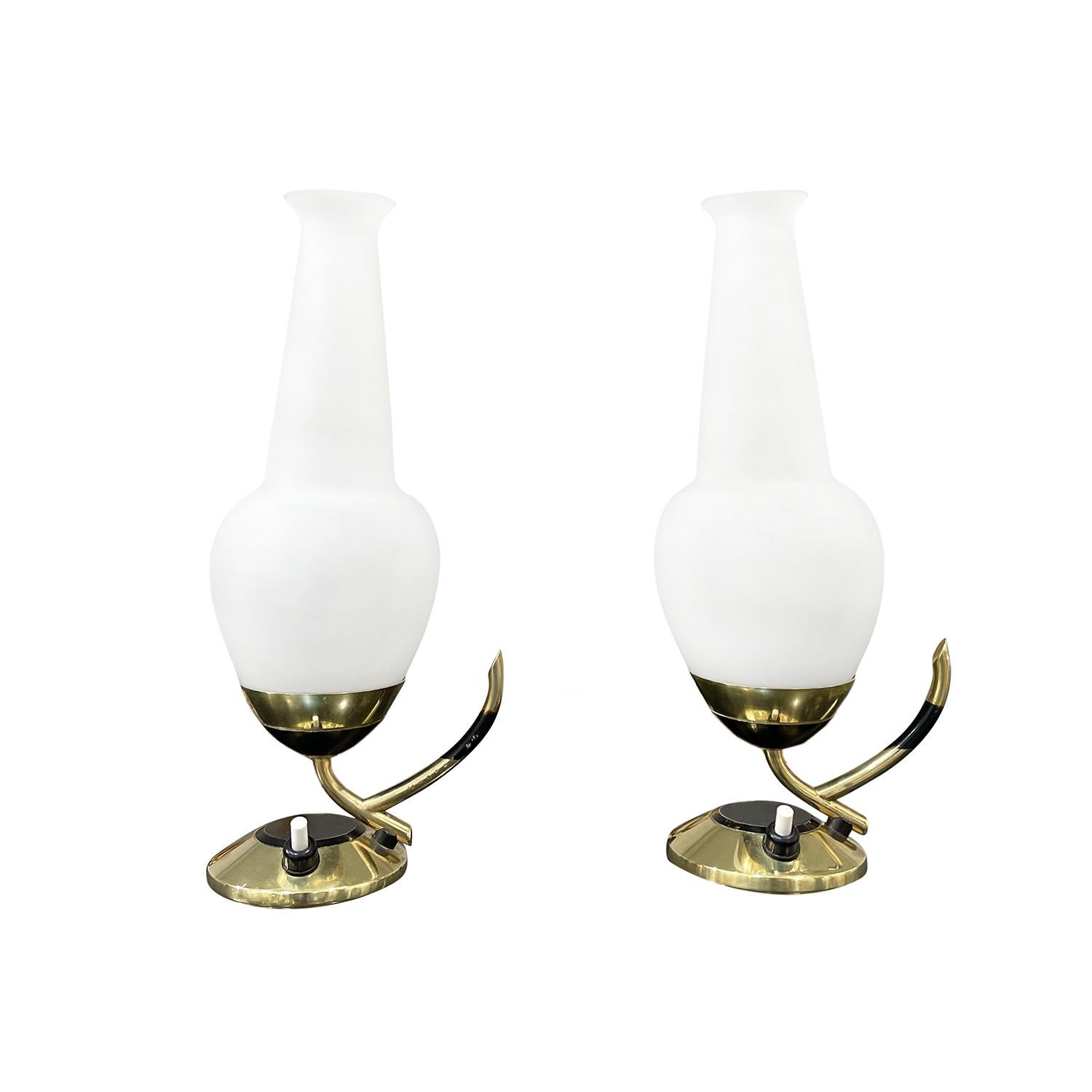 A gold, small vintage Mid-Century Modern Italian pair of table lights made of hand crafted polished brass, designed and produced by Stilnovo in good condition. The tulip glass shades are made of hand blown frosted opaline glass, halted by a round