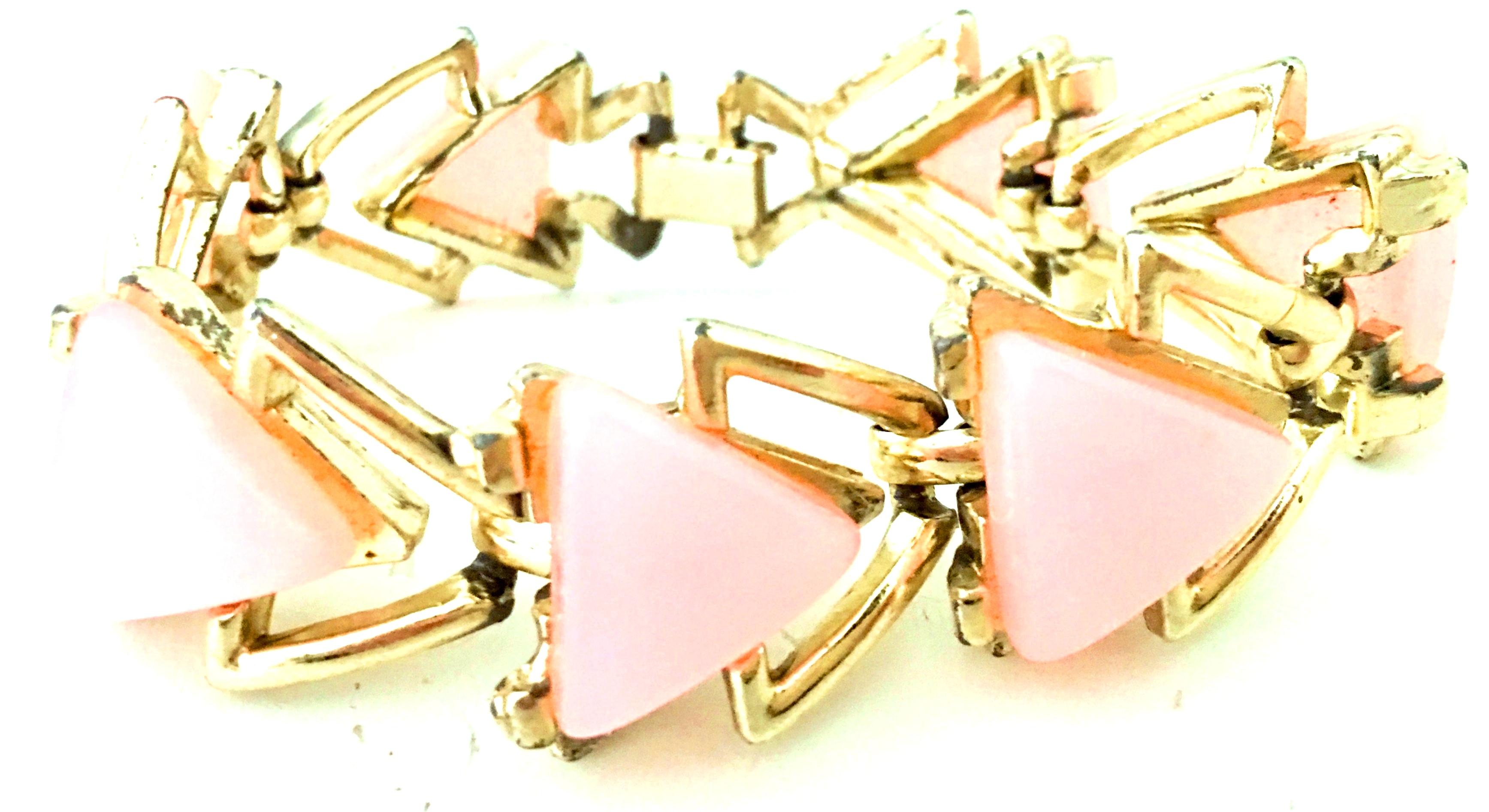 20th Century Gold & Pink Lucite Link Bracelet By, Coro. Features gold plat metal with six pink Lucite triangles and seven gold triangle links. Fold over box style locking clasp.
Each pink Lucite triangle is approximately, .75
