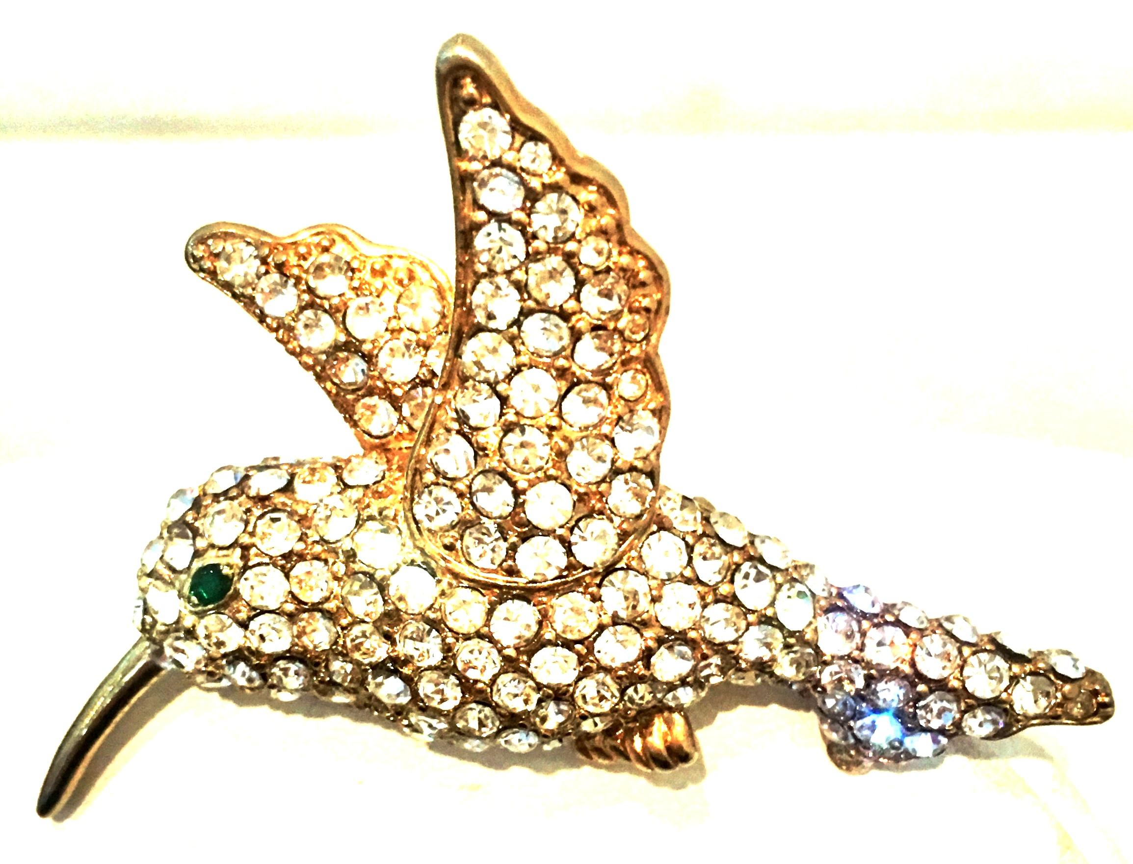 20th Century Gold Plate & Swarovski Crystal Dimensional Hummingbird Brooch.
Features pave set round cut and faceted colorless Swarovski Crystal stones. The hummingbirds eye is of emerald green in color.