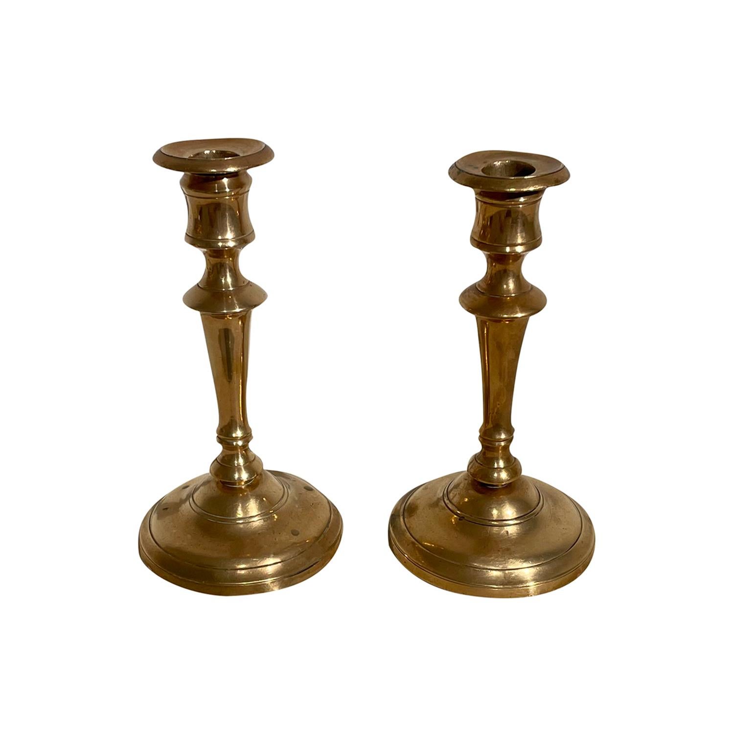A gold, Swedish Gustavian pair of candle holders made of hand crafted bronze, designed and produced by Skultuna in good condition. The Scandinavian candlesticks, stands are enhanced by derail craft art. Signed SB at the bottom. Model Nr. 15. Wear