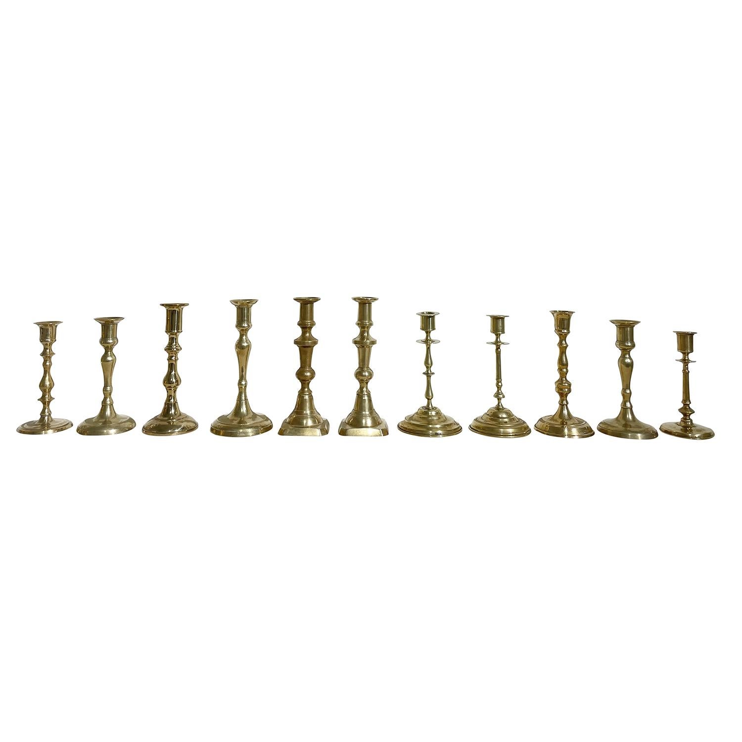 A gold, vintage Swedish Gustavian similar set of eleven candle holders made of hand crafted brass, in good condition. The Scandinavian candlesticks, stands are enhanced by derail craft art. Wear consistent with age and use. circa 1960 - 1980,
