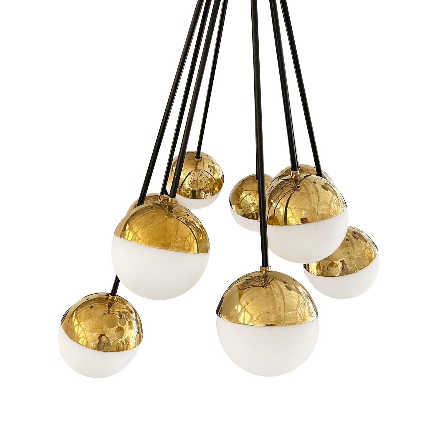 A gold-white, vintage Mid-Century Modern Italian chandelier, pendant made of hand crafted polished brass, designed and produced by Stilnovo in good condition. The small round sputnik ceiling light, lamp is composed with nine frosted opaline glass