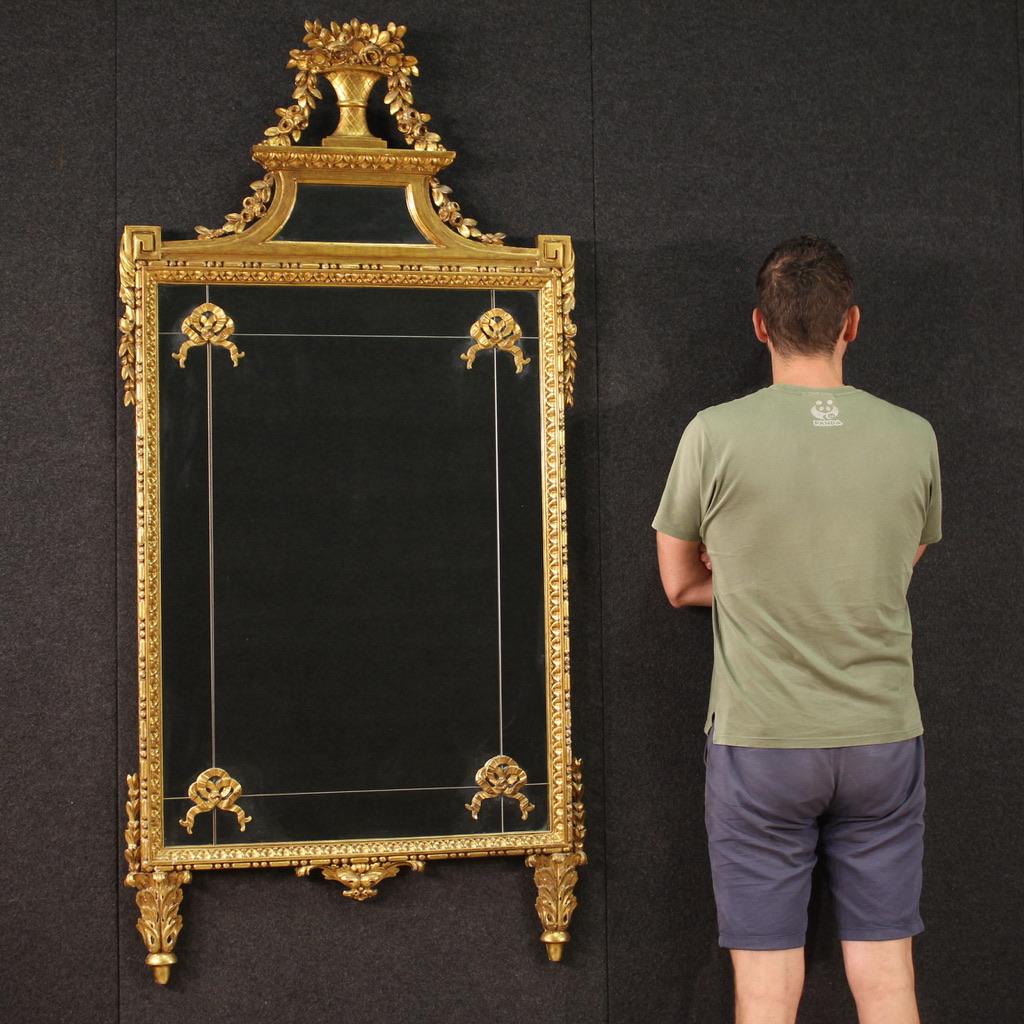 Italian mirror from the second half of the 20th century. Furniture built in a single body, in carved and gilded wood, in Louis XVI style of beautiful lines and pleasant furnishings. Mirror of excellent size and great elegance, ideal for placing in a