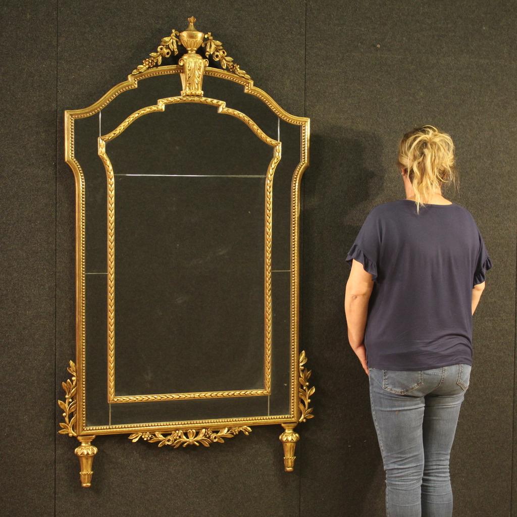 Élégant miroir italien de la seconde moitié du XXe siècle. Meubles en bois finement sculptés et dorés, de style Louis XVI, d'une grande qualité et d'un grand impact. Miroir idéal à combiner avec une table pliante ou une commode, soutenu par deux