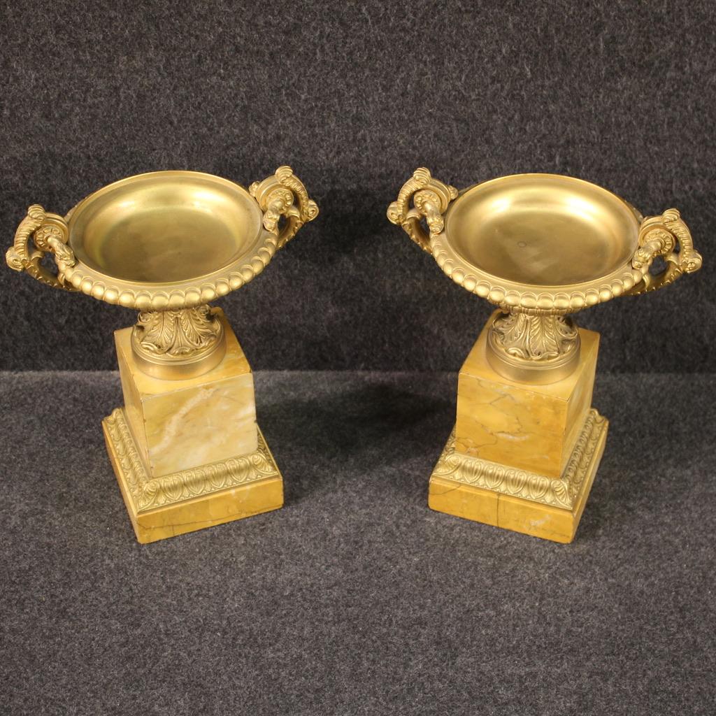 Pair of Italian centerpieces from the first half of the 20th century. Objects in gilded and chiseled bronze with a square plinth base veneered in marble. Centerpieces of fabulous decor, ideal for displaying above a fireplace or desk, for antique