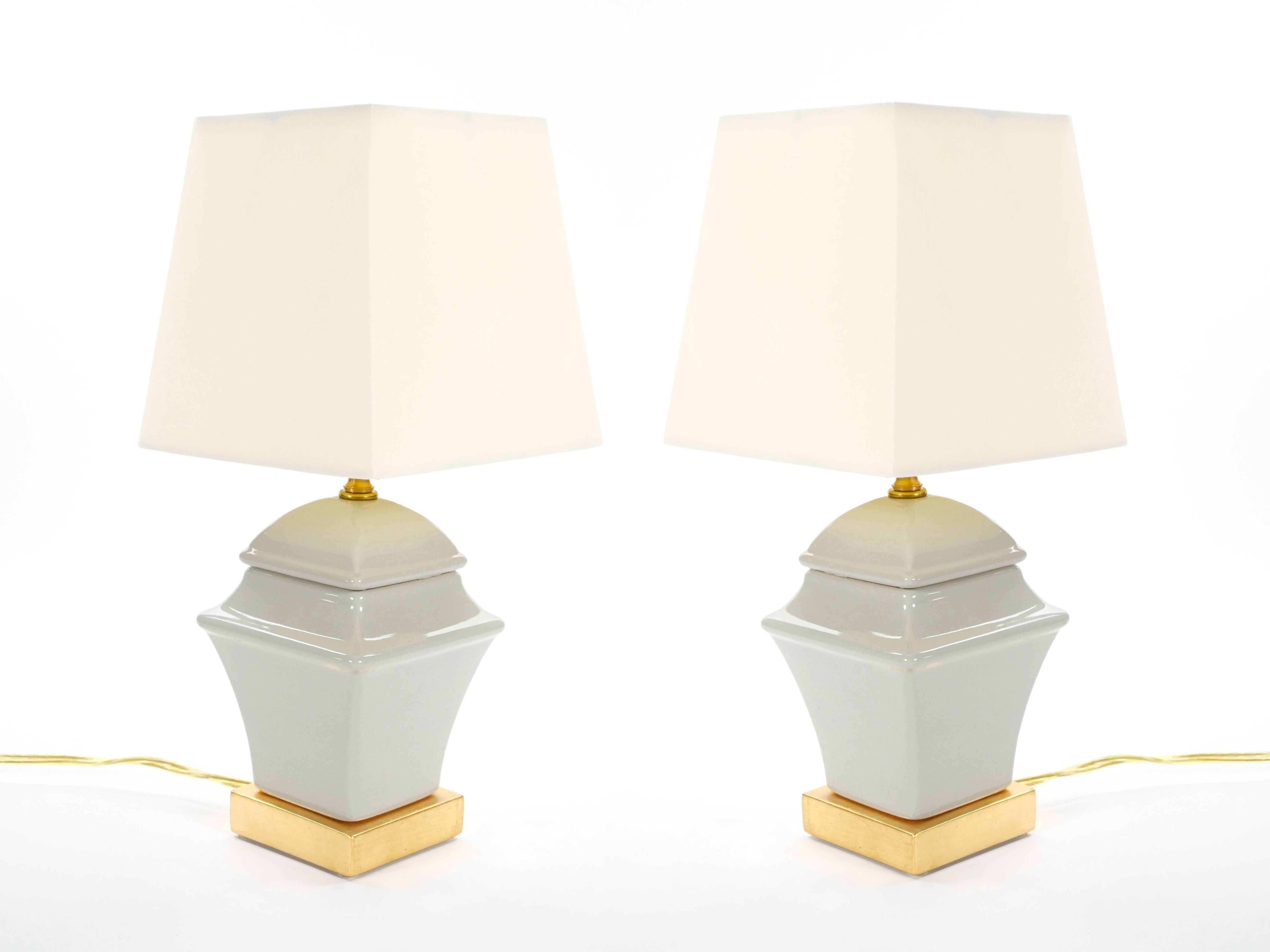 Cette charmante lampe de table de la fin du XXe siècle présente un vase sophistiqué en porcelaine grise irisée et un socle en bois peint en or magnifiquement doré. La forme élégante et carrée du vase de la lampe repose gracieusement sur une base