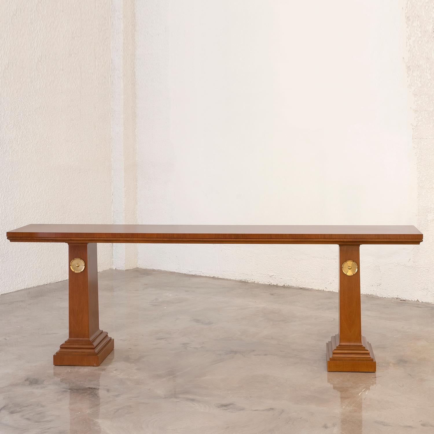 A light-brown, vintage Mid-Century Modern Greek console table made of hand crafted polished Walnut, designed by T.H. Robsjohn-Gibbings and produced by Saridis of Athens, in good condition. The tall freestanding end table is supported by two wooden