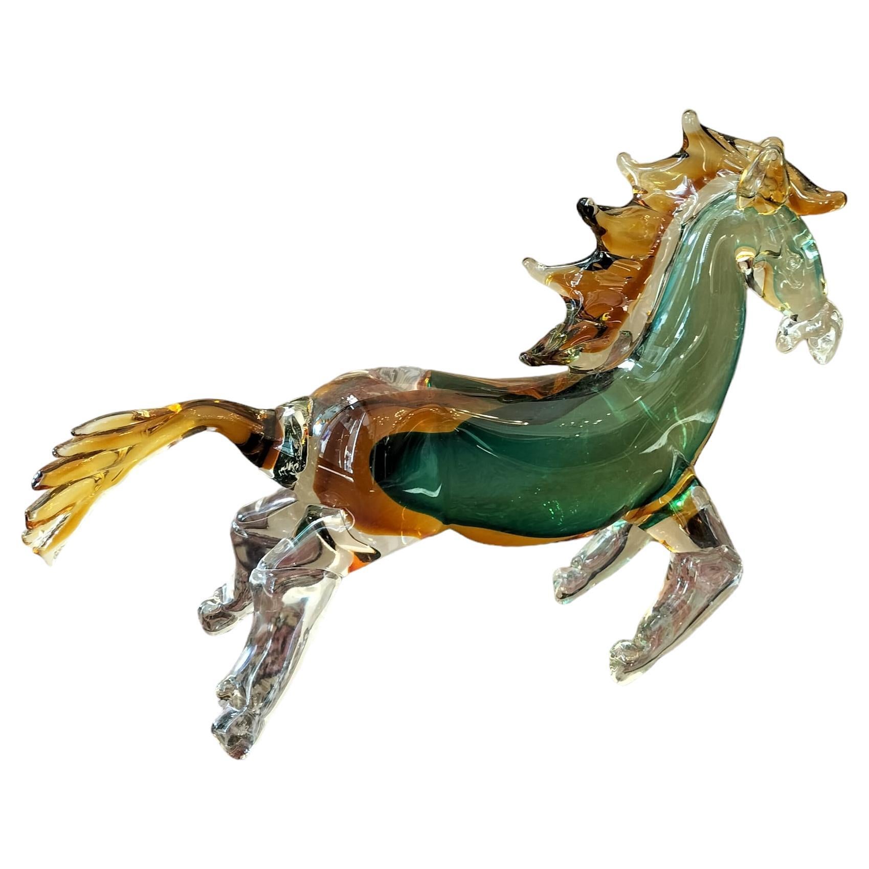 This beautiful animal sculpture, depicting a galloping horse crafted from Murano glass in vibrant green and yellow hues, was made in the late 20th century. It bears the artist's signature discreetly placed on the inner stomach of the horse. It