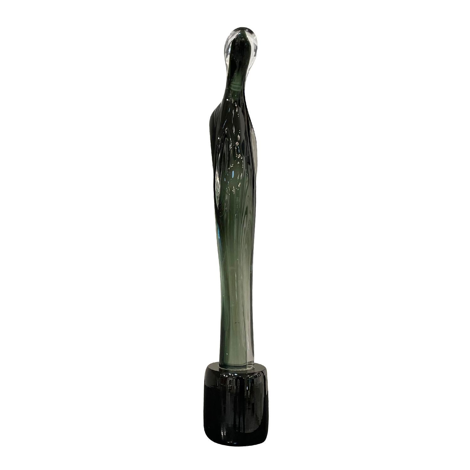 Sculpture abstraite haute et arquée en verre de Murano coloré soufflé à la bouche, en bon état, de couleur vert clair et noir. La pièce décorative en verre fumé est soutenue par une base ronde. Usure conforme à l'âge et à l'utilisation. Circa 1970 -