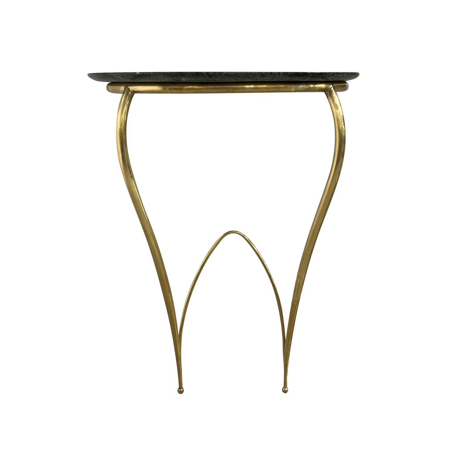 A half round, vintage Mid-Century modern Italian pair of wall mounted console tables made of hand crafted metal, brass with a green Belgian marble top, in good condition. The demi-lune end, side tables are standing on two sculptural legs, designed