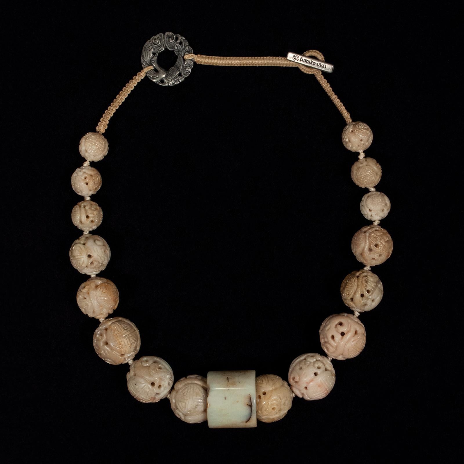 20th century Jade and Stone Necklace by Fumiko Ukai of Berkeley, CA

An elegant necklace created by the late Berkeley jewelry designer Fumiko Ukai, composed of nicely graduated carved stone beads with a polished jade archer's ring at the center. The