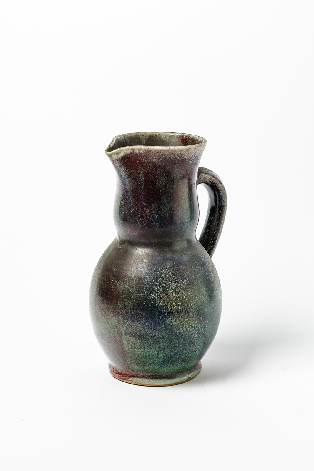 Jean Maubrou.

Large stoneware ceramic pitcher.

Green and colored stoneware ceramic glazes colors.

Signed under the base.

Original perfect condition.

Height 28 cm.

Large 19 cm.