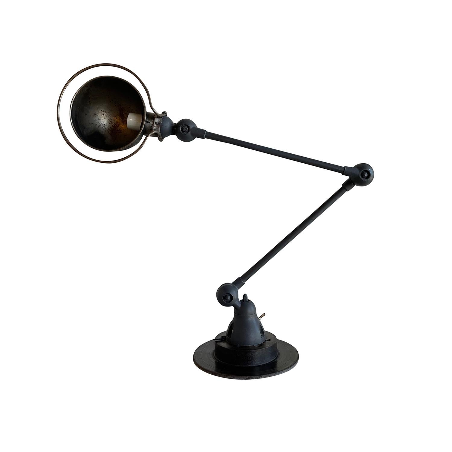 A grey-black, vintage Mid-Century Modern French desk light made of hand crafted metal, designed by Jean Louis Domecq and produced by Jielde, in good condition. The industrial car brake, table lamp is composed with two adjustable arms, featuring a