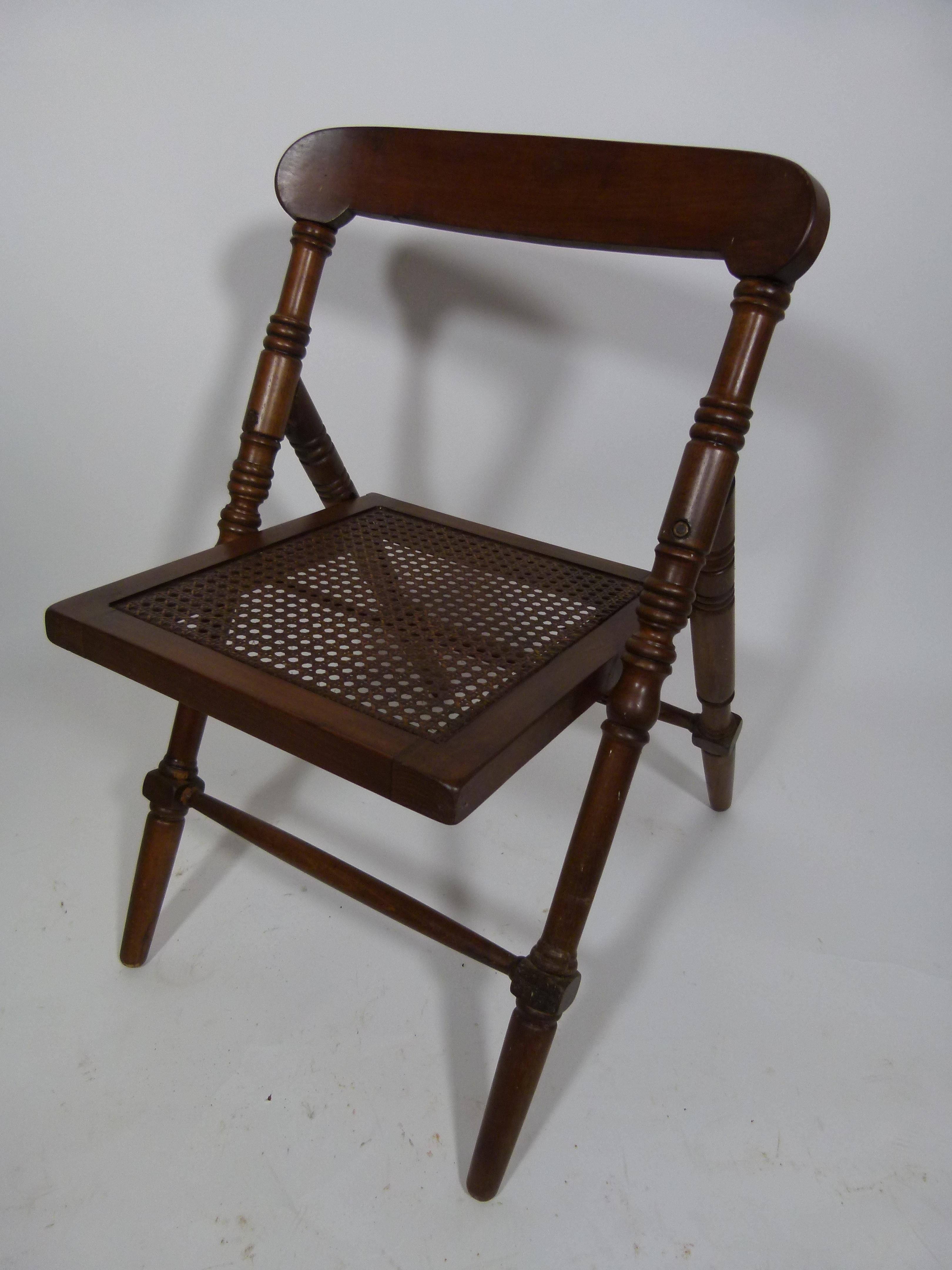 Folding chair from the early 20th century. Black varnished wood and gridded seat.
On the wood seat's frame there is the Manufacture's logo: 