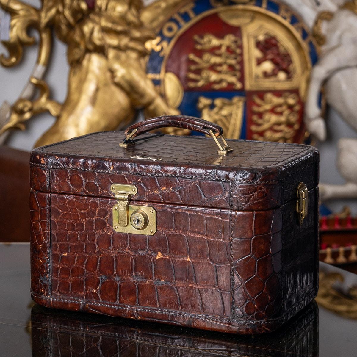 A stunning mid 20th Century crocodile leather & brass overnight vanity case by Gucci of Florence, Italy. This case features a leather carrying strap on the lid along with a locking mechanism on the front & sides. The inside is lined with fabric and