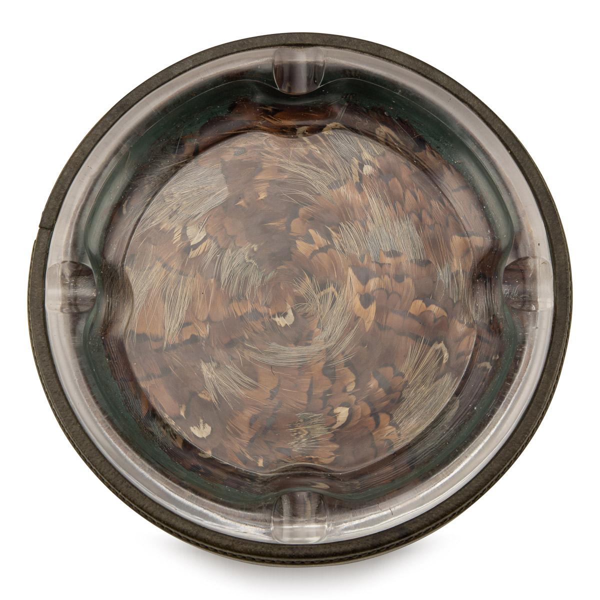 Stunning mid-20th century Gucci very large glass ashtray. The plain rim with four cigar rests, with feathers under glass. Has the original Gucci retail mark, made in Italy. it is easy to imagine the appeal behind these objects which would have made