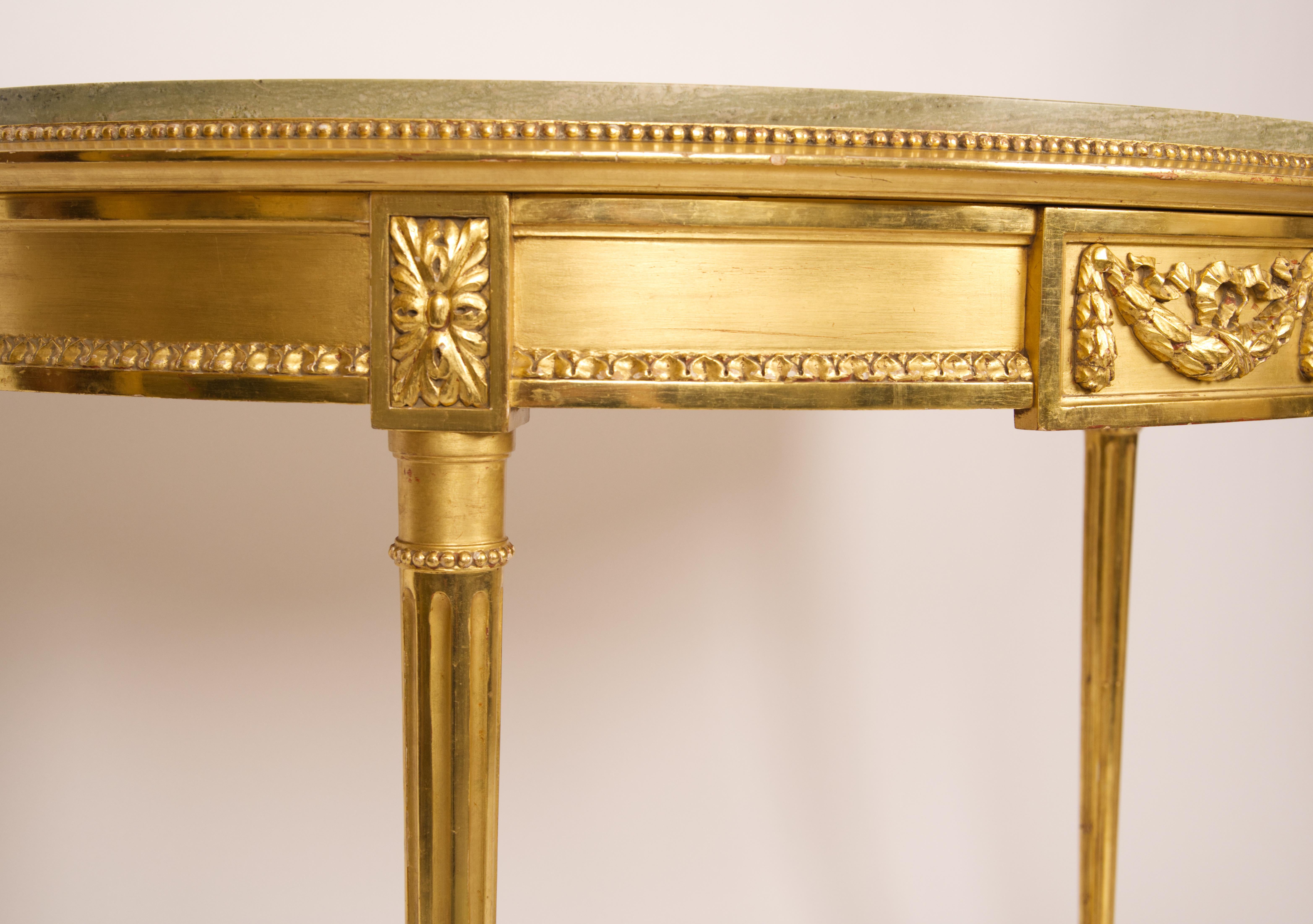 Gold gilded Gustavian styled table with intricate carvings around the frame and legs with a green marble top resting upon the frame. Marked by a NK Nordic company seal.