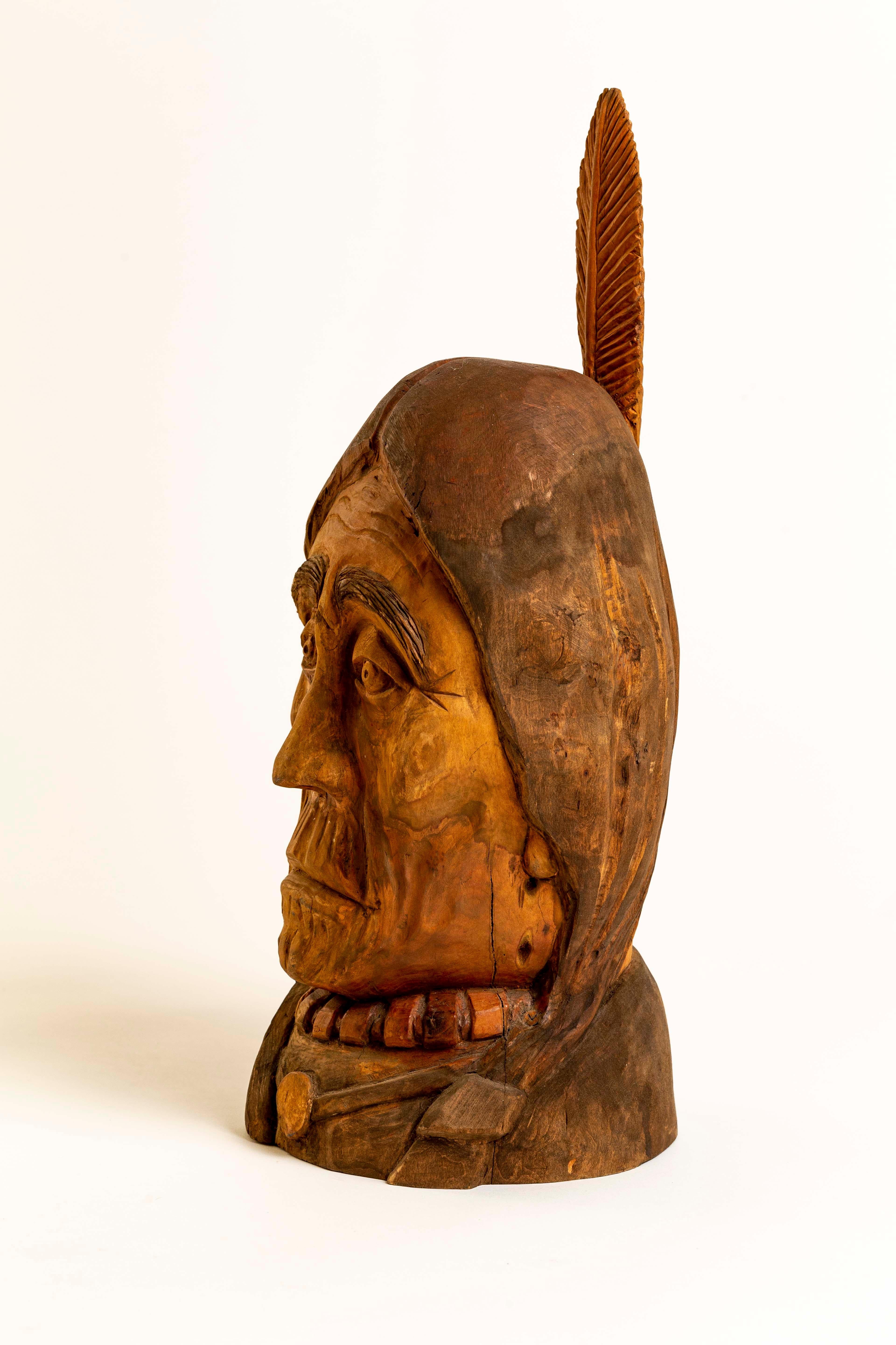 Available for your consideration is an original hand carved sculpture by Duane Hansen. 
This object of art depicts a Native American gentleman with a single feather in his hair. His gaze is captivating and face is very detailed and expressive. An