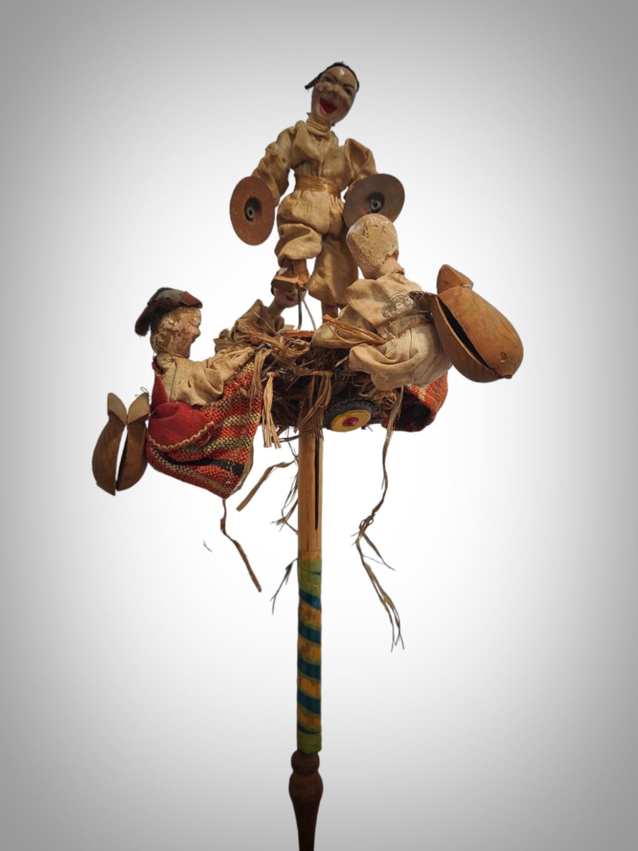 Type: Hand-cranked Automaton Toy
Era: Early 20th Century
Functionality: When the central tube is manually raised and lowered, the characters move.
Dimensions: 55 x 30 x 30 cm
Features and Details:
This intriguing hand-cranked automaton toy from the