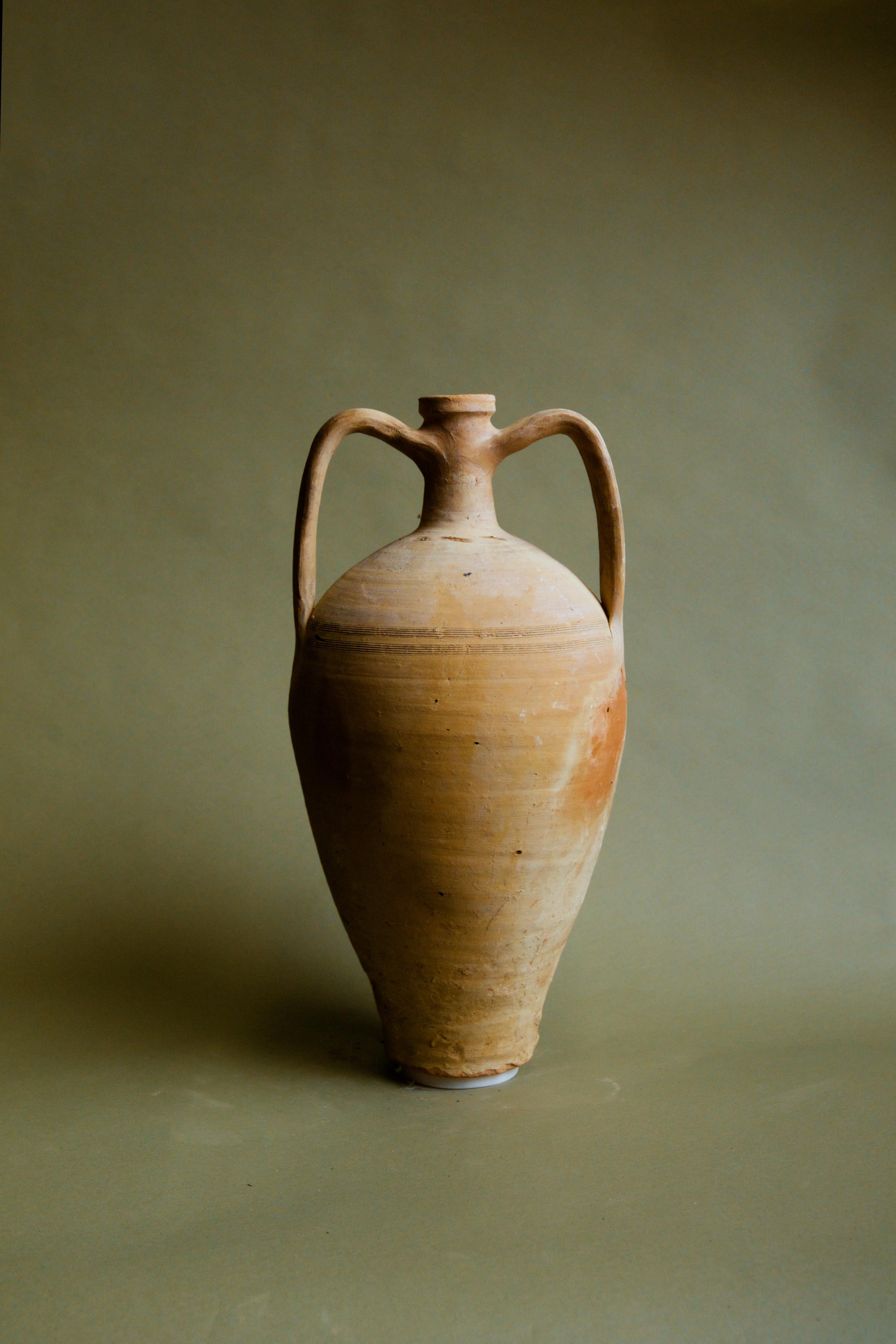 Cette amphore artisanale de Cappadoce datant du 20e siècle est un bel exemple de l'art de l'argile anatolienne. Elle est parfaite pour ajouter une touche d'héritage turc aux intérieurs rustiques, méditerranéens, aux fermes, aux cottages et aux