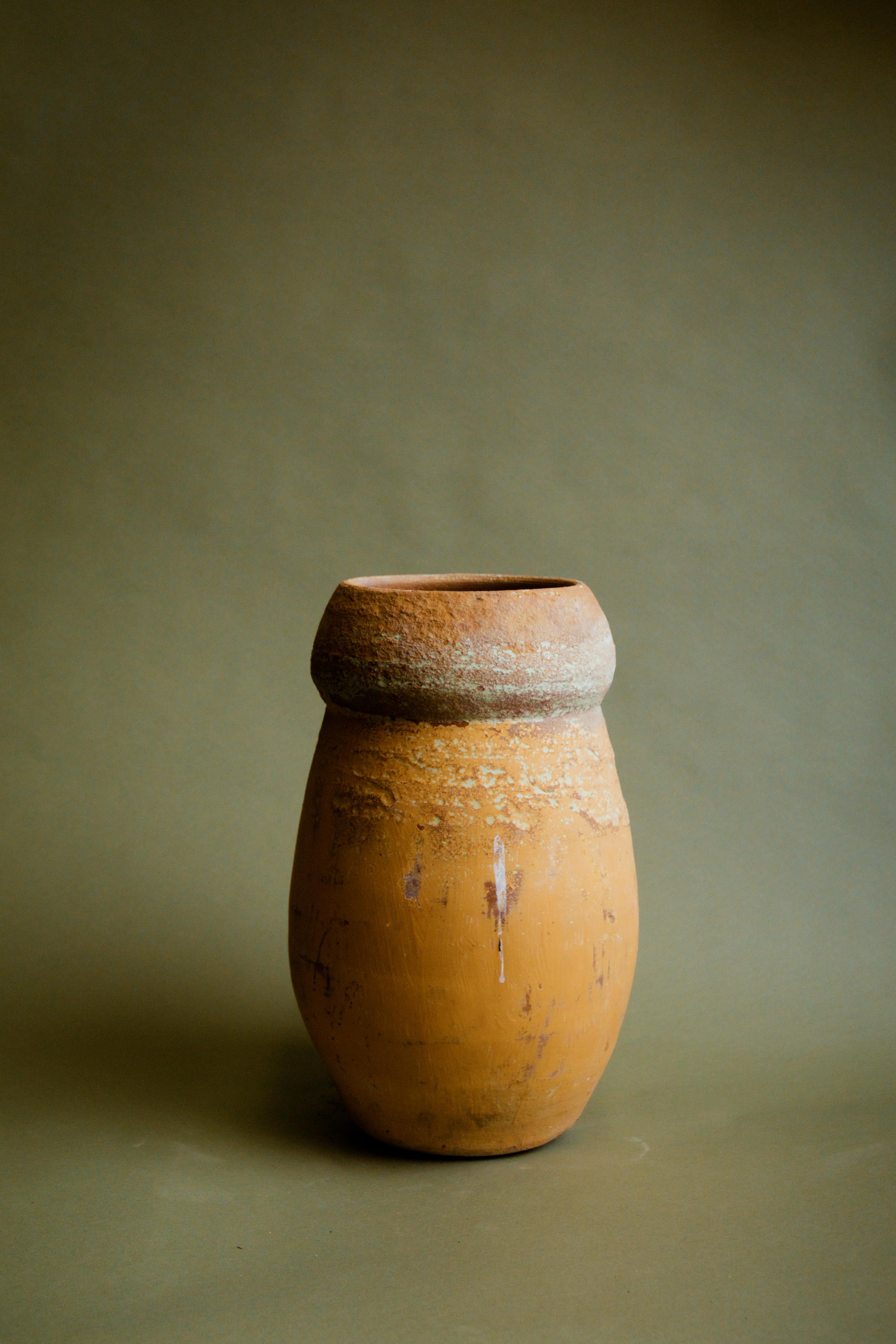 Questo vaso da stoccaggio in colletto invecchiato del XX secolo è uno splendido esempio di artigianato anatolico, perfetto per aggiungere un tocco autentico a interni rustici, mediterranei, casalinghi e di ispirazione cottagecore. Realizzato a mano