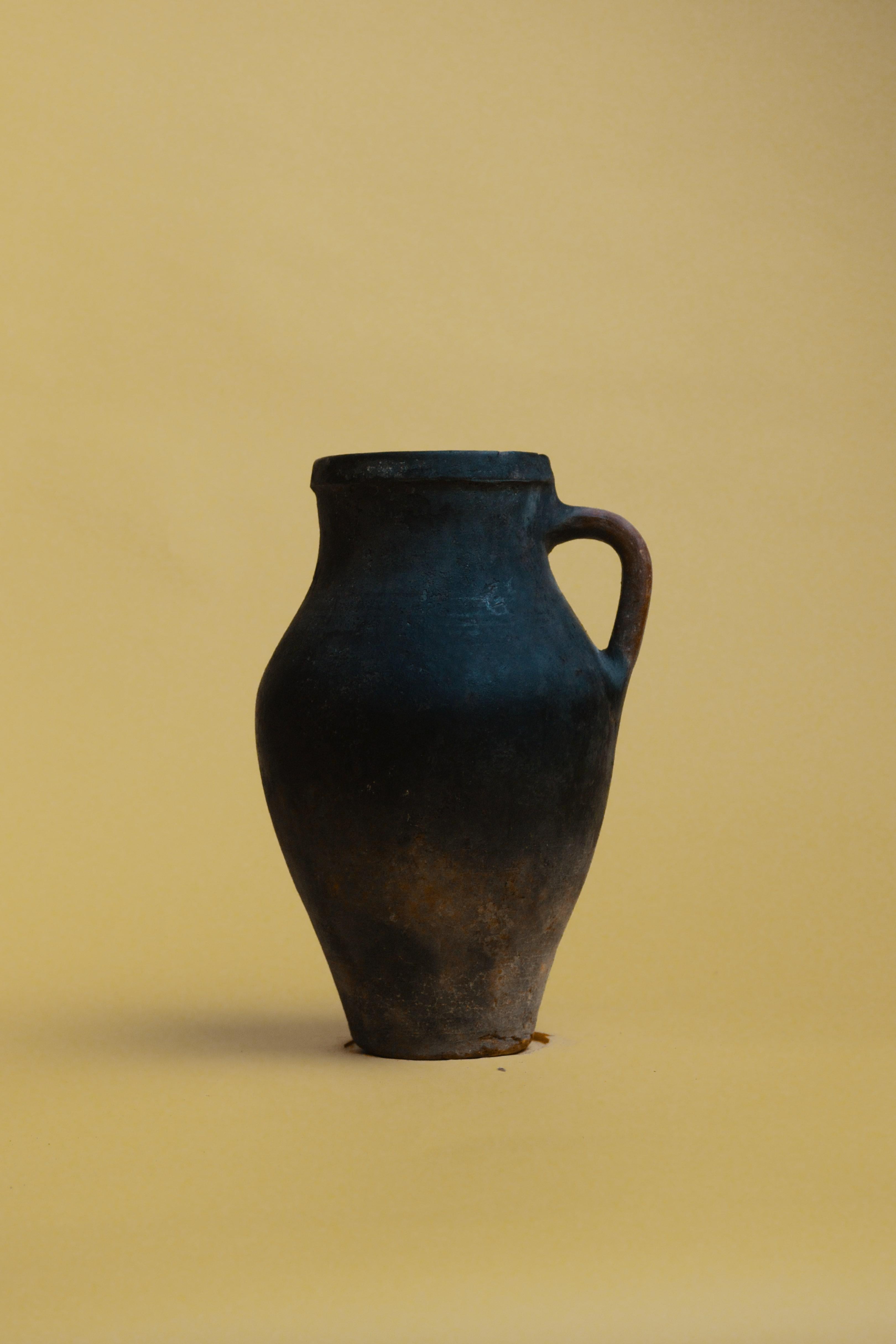 Incarnando l'essenza dell'artigianato tradizionale, questo vaso vintage in argilla cotta turca è uno splendido esempio di ceramica mediterranea e anatolica. Realizzato con antiche tecniche di cottura, questo vaso rustico in terracotta presenta una