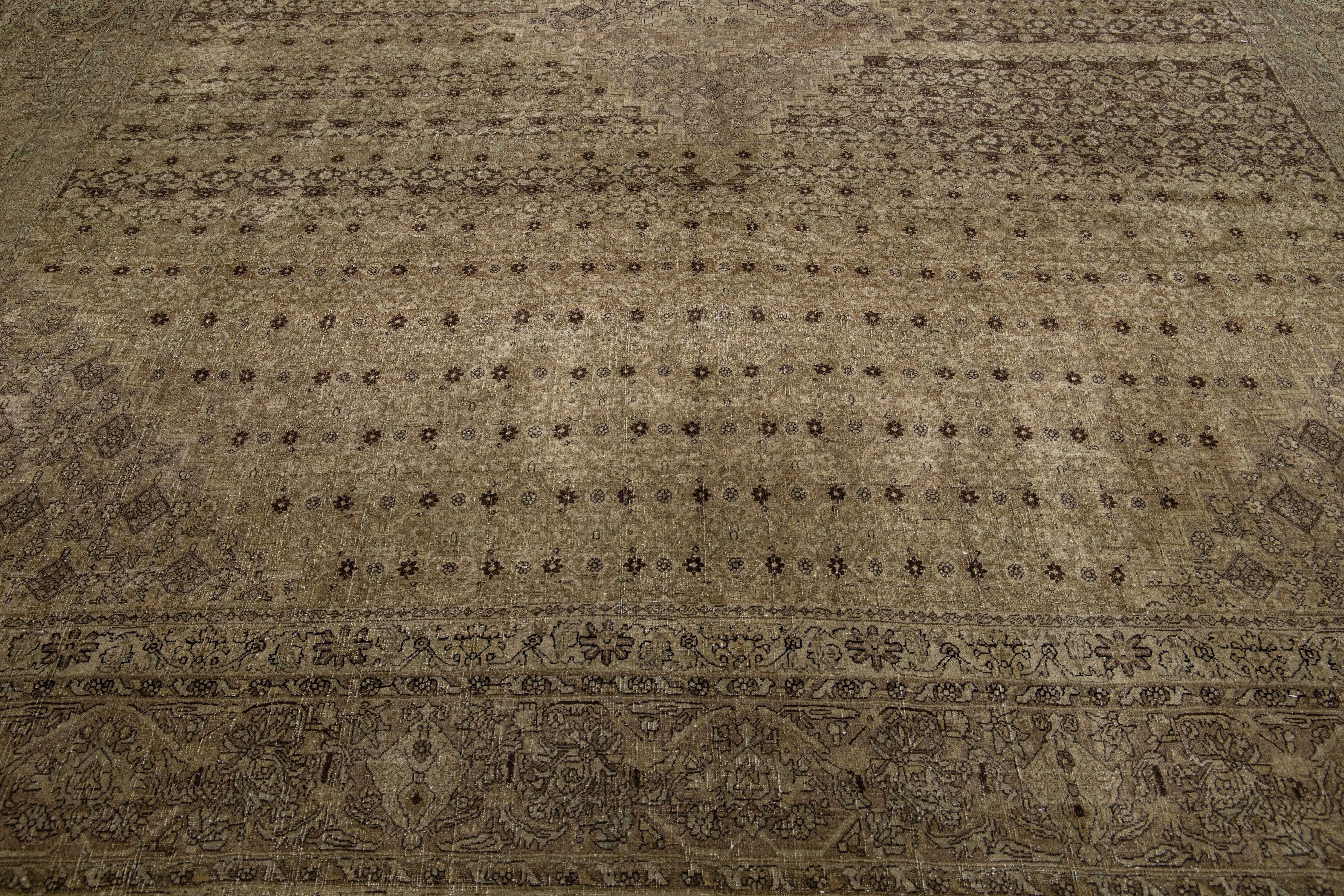 Ce tapis Tabriz antique présente un champ de couleur marron et une construction exquise en laine nouée à la main, complétée par des touches de bleu dans un motif floral sur toute la surface.

Ce tapis mesure : 11'3