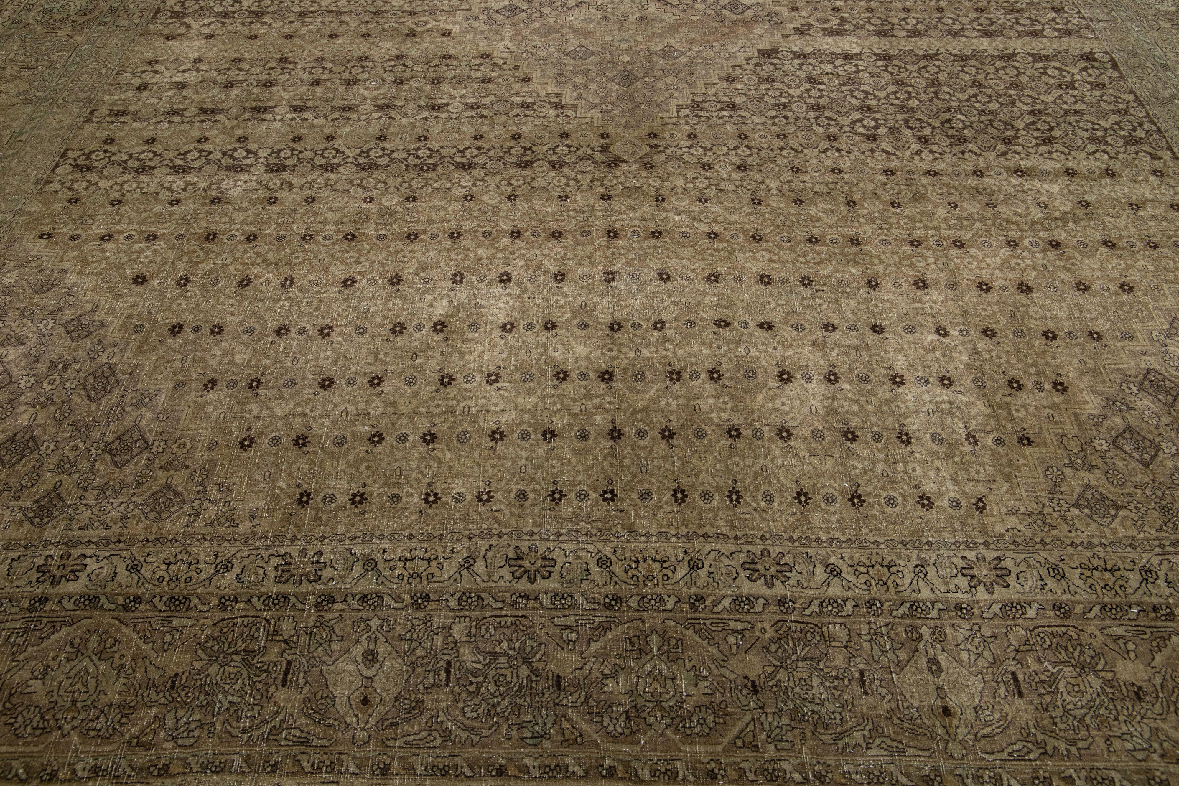 Questo antico tappeto Tabriz vanta un campo di colore marrone e presenta una squisita costruzione in lana annodata a mano, completata da accenni di blu in un motivo floreale all-over.

Questo tappeto misura: 11'3